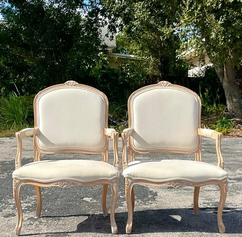 A fabulous pair of vintage Regency Bergere chairs. Beautiful hand carved detail on the classic shape. Acquired from a Palm Beach estate.
