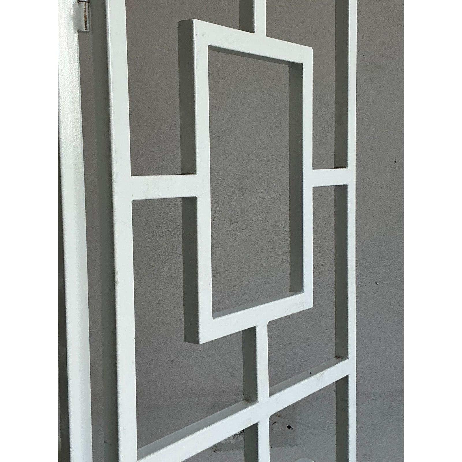 Introduce architectural elegance and graphic flair into your interior with this stunning vintage folding screen. Inspired by the iconic fretwork of Hollywood Regency and Chinoiserie design, this three-panel screen features a bold, repeating