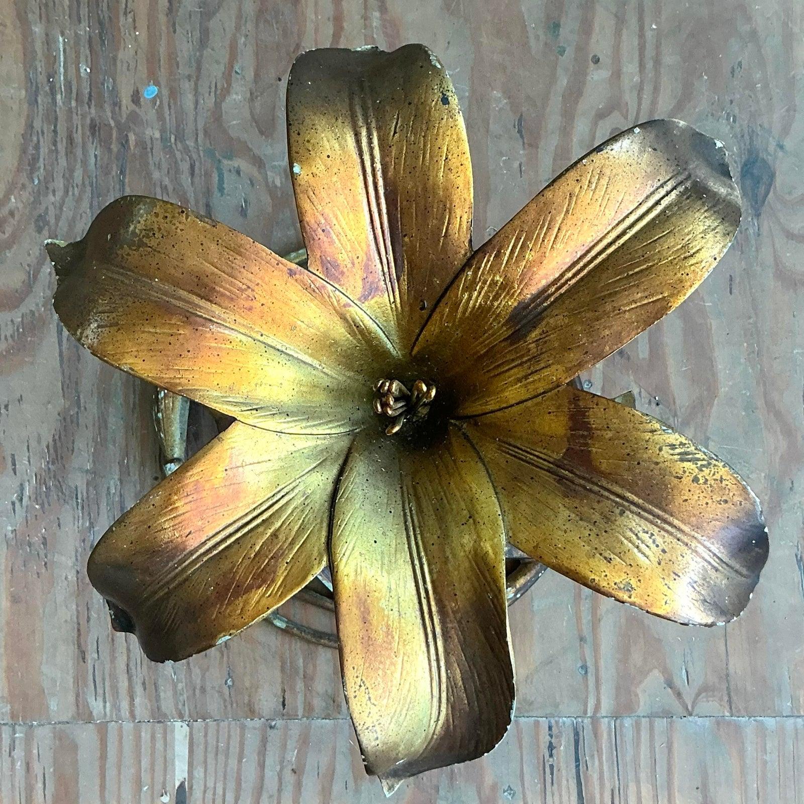 A stunning example of Hollywood Regency glamour, this sculptural blossom table captures the romance of botanical art. Meticulously crafted from gilt and patinated metal, this piece showcases the fluid, organic forms popularized by legendary