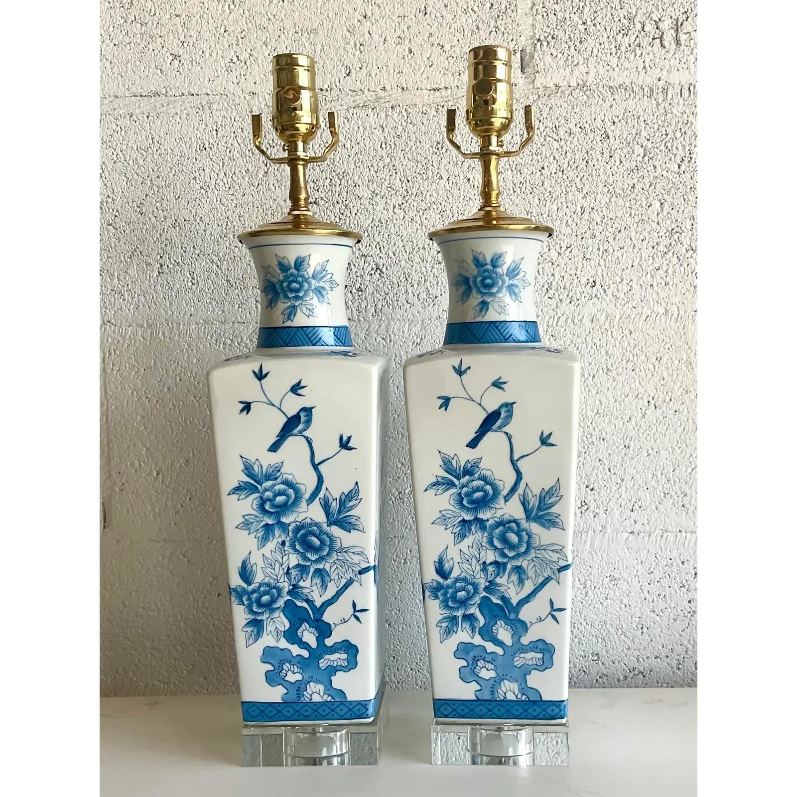 Vintage pair of Regency glazed ceramic table lamps. Beautiful blue and white chinoiserie print. All new hardware and wiring with sparking new crystal plinths. Acquired from a Palm Beach estate.
