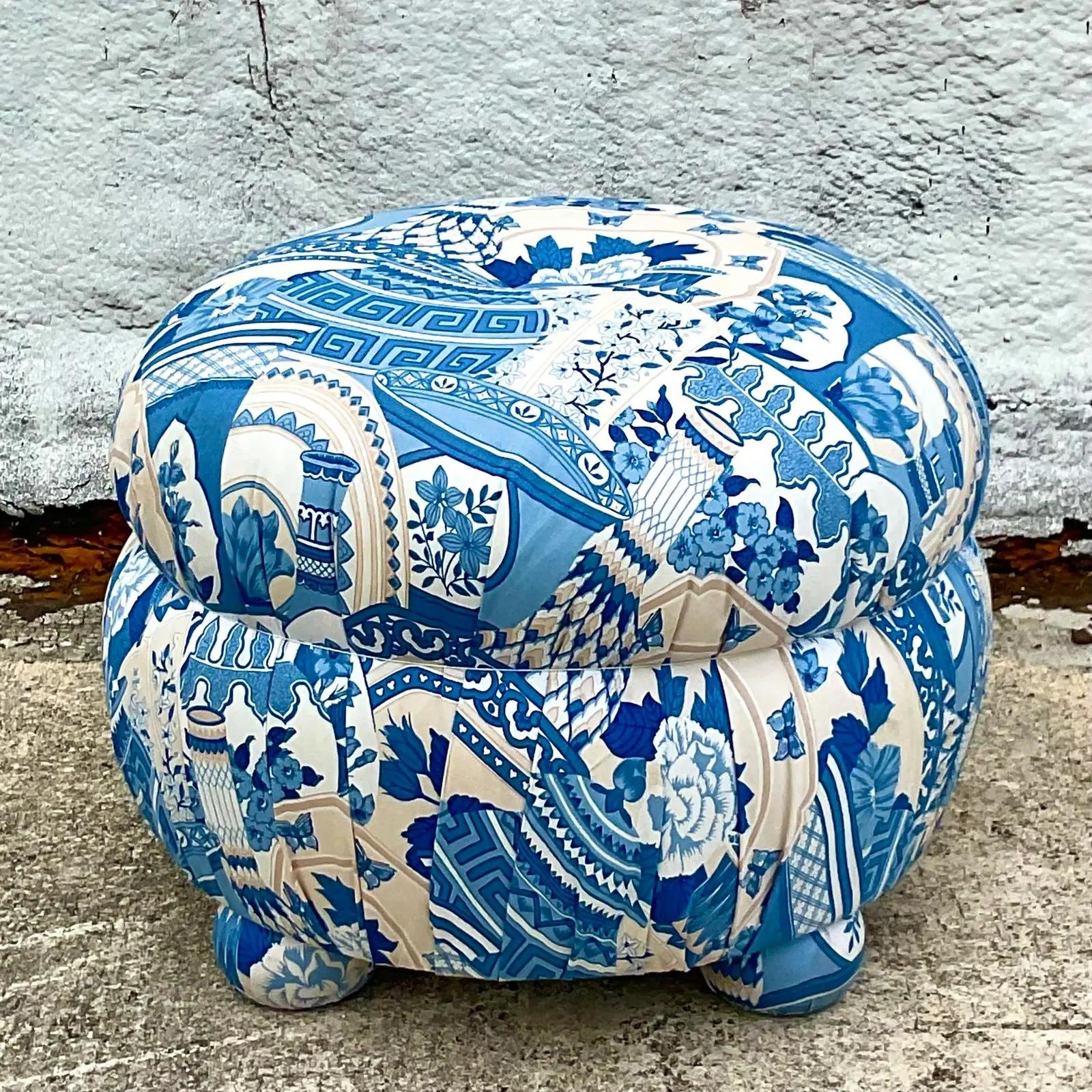A fabulous vintage Regency ottoman. A beautiful blue and white Asian ginger jar print. A single tufted top and upholstered feet. Acquired from a Palm Beach estate.