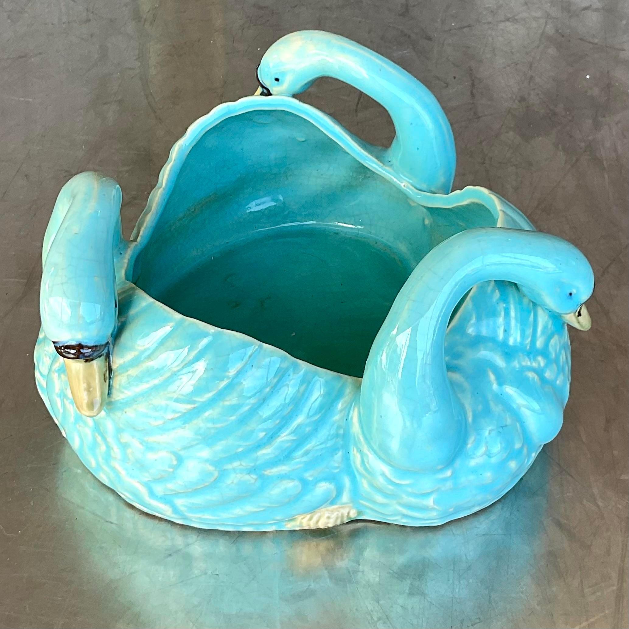 A fabulous vintage Regency centerpiece bowl. A brilliant turquoise blue with a glazed ceramic finish. A ring of three swans gilt tipped beaks. Acquired from a Palm Beach estate.