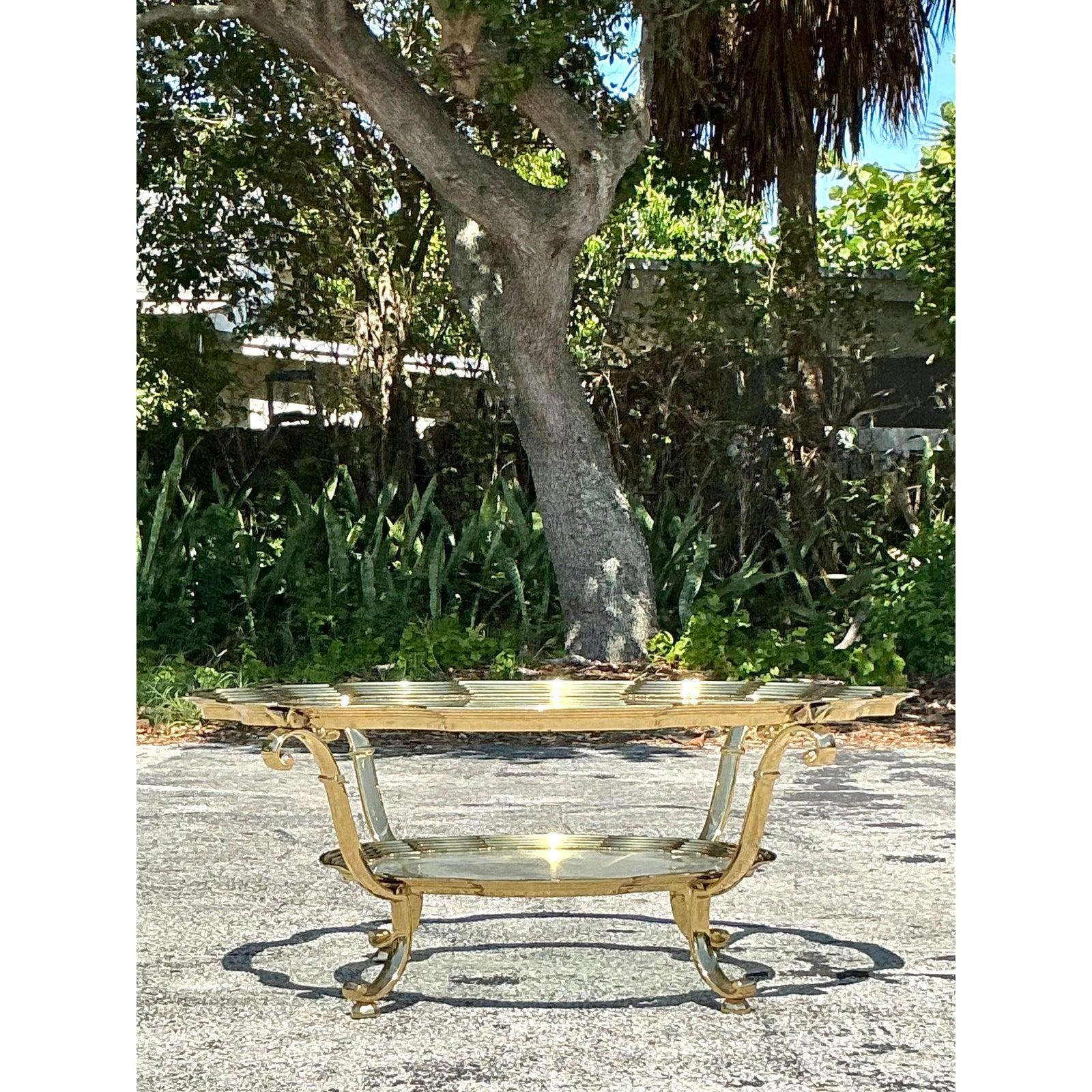 Channel timeless Hollywood Regency glamour with this stunning vintage coffee table, crafted in the esteemed style of La Barge. This elegant piece features a substantial round glass tabletop with a beautifully scalloped or petal-shaped edge, resting
