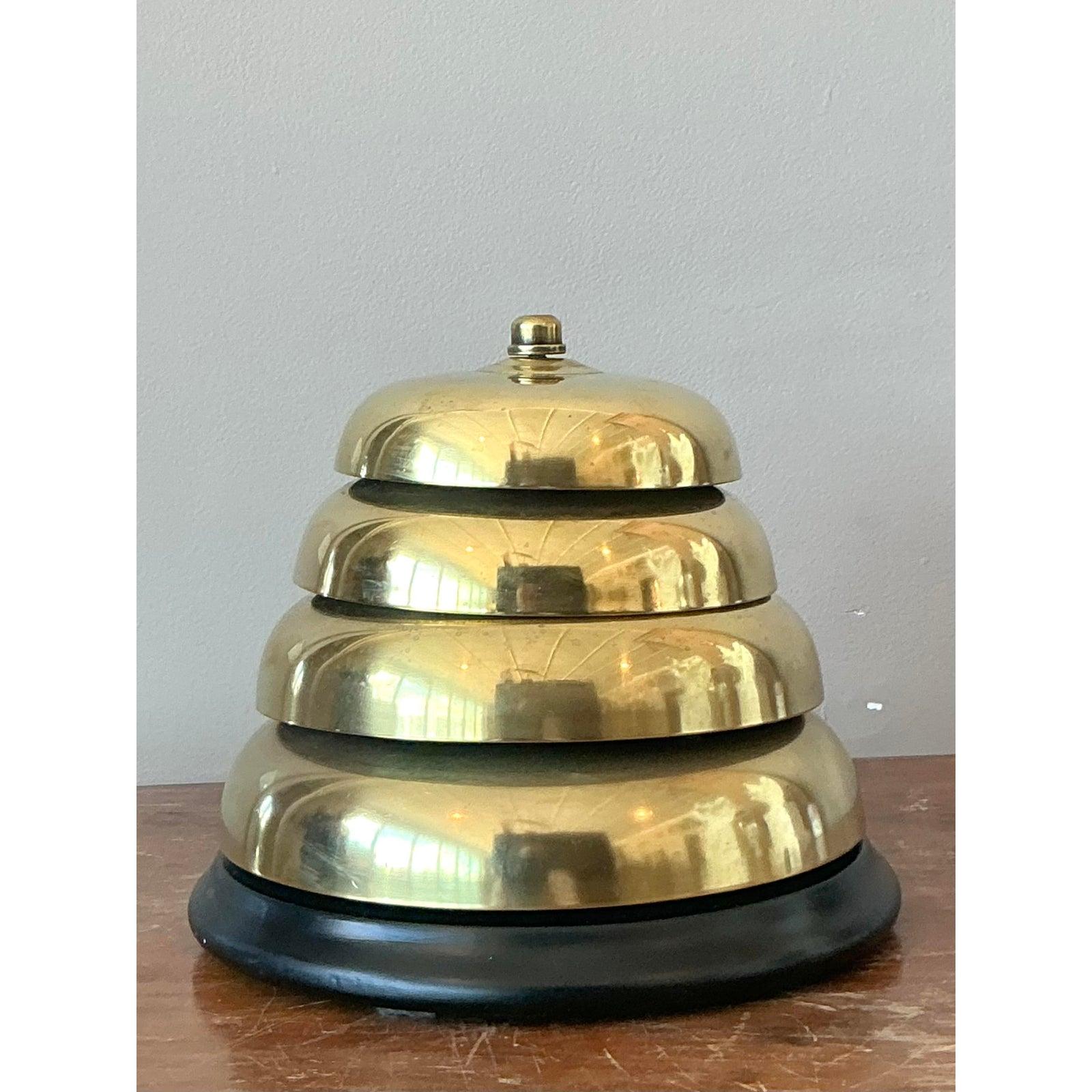 Cette exquise cloche à dîner en laiton à étages de style Vintage Regency, accompagnée de son maillet d'origine, attire l'attention. Cette pièce sophistiquée présente un design en laiton étagé magnifiquement poli qui brille d'une élégance classique