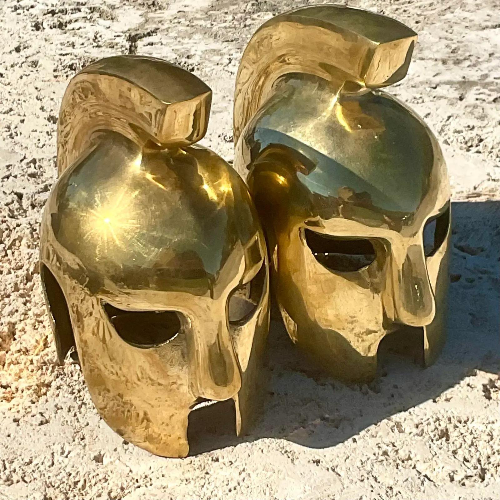 A fabulous pair of vintage Regency bookends. Chic brass gladiator helmets in a high polish finish. Acquired from a Palm Beach estate.