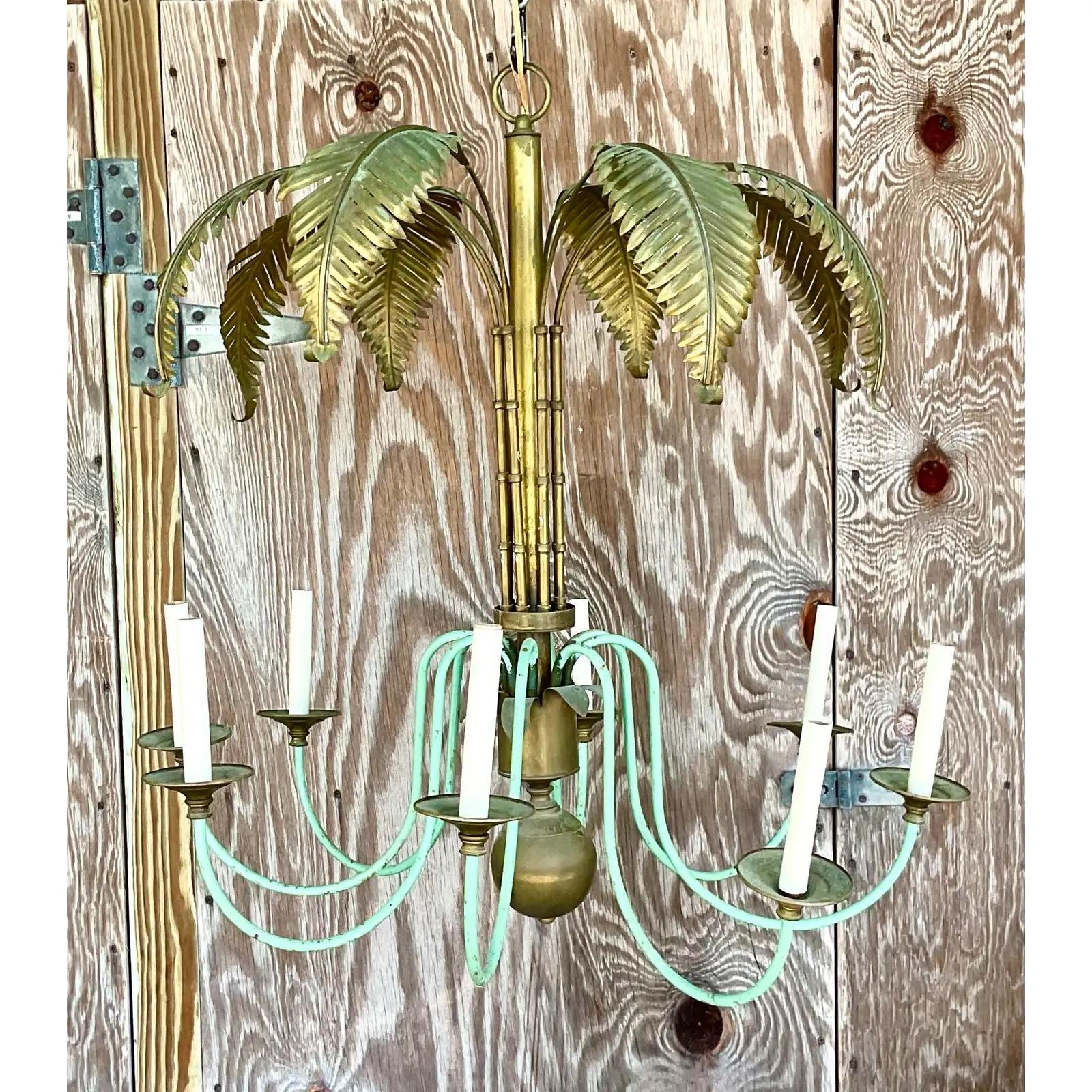 Incredible vintage Regency chandelier. Beautiful brass fronds with 8 pale green painted arms. A fabulous patina from time. Perfect as is or painting it white for a more Coastal look. Acquired from a Palm Beach estate.

The chandelier is in great