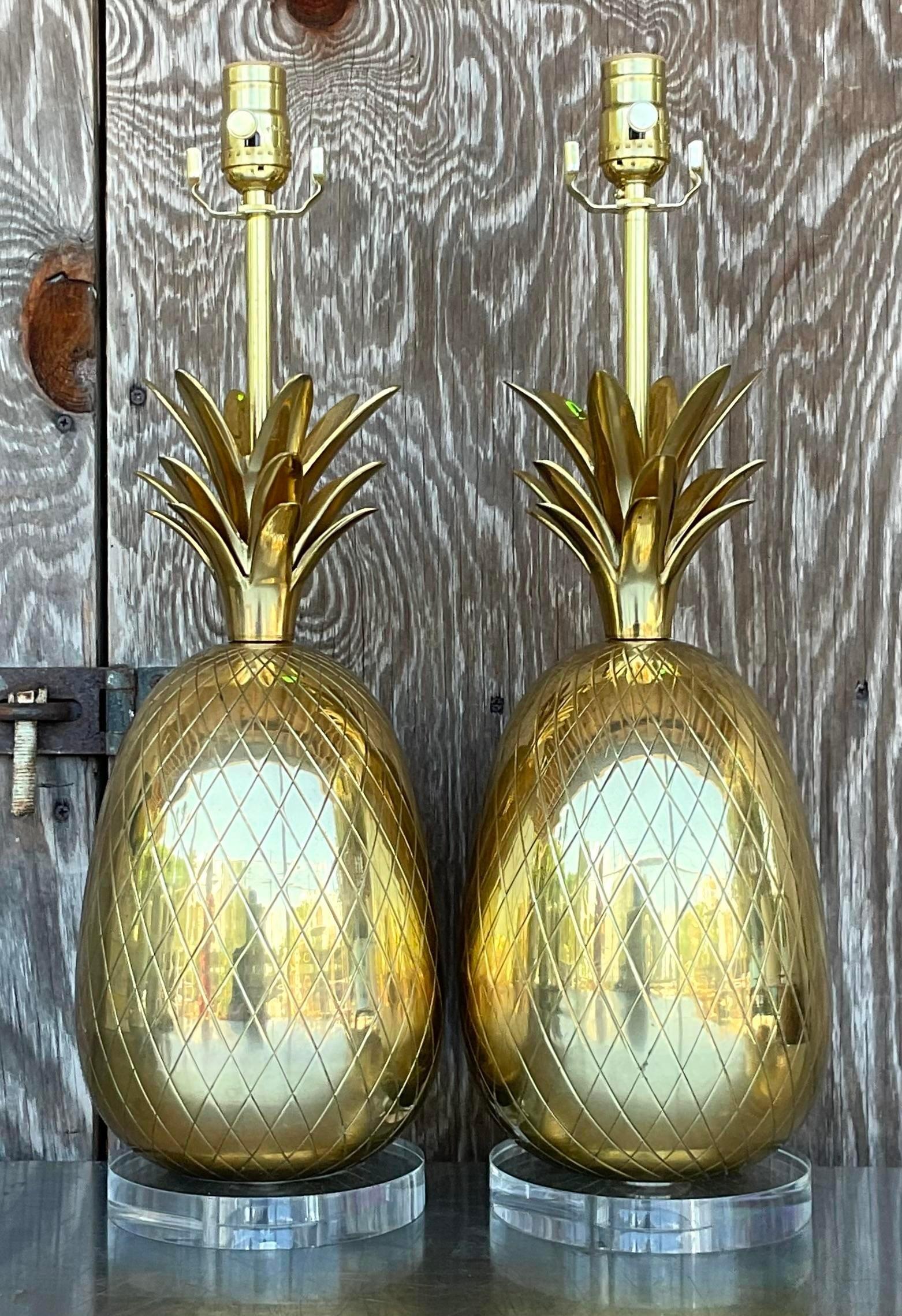 A sensational pair of vintage Regency table lamps. A chic pair of brass pineapples on lucite plinths. Fully restored with all new wiring and hardware. Acquired from a Palm Beach estate.