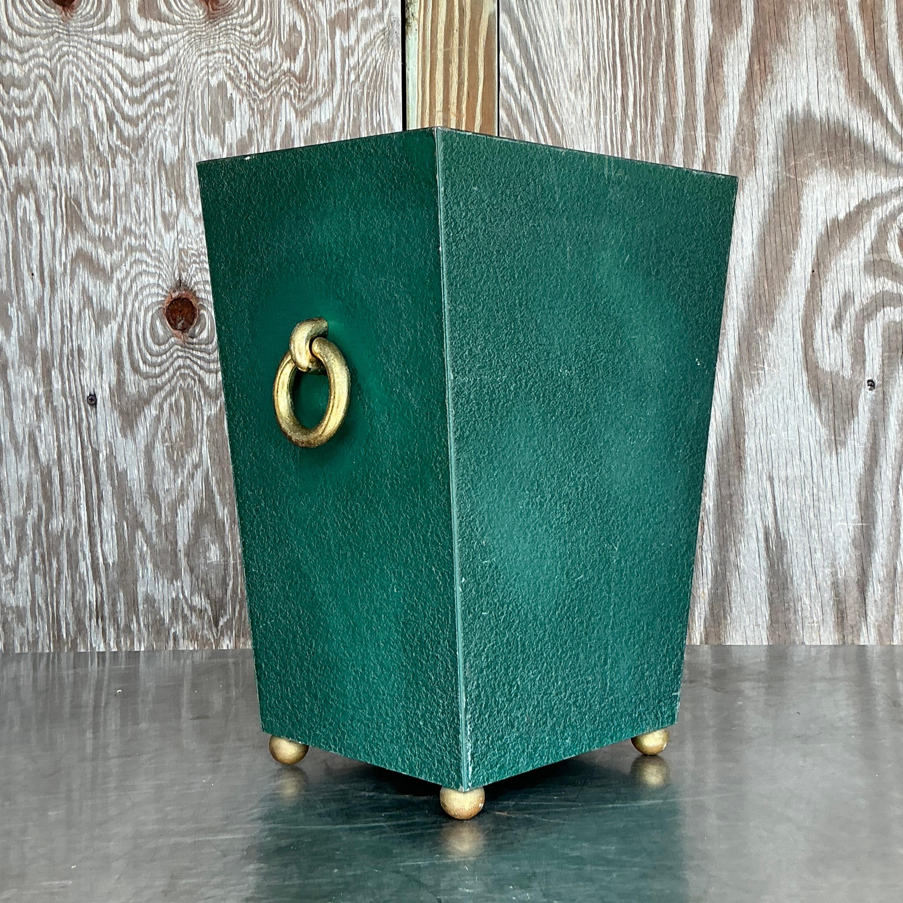 Questo cestino vintage Regency in ottone con anelli e ciottoli è un mix sofisticato di forma e funzione. Caratterizzato da una texture a ciottoli e da eleganti inserti in ottone, dona un tocco di eleganza americana senza tempo a qualsiasi ambiente.