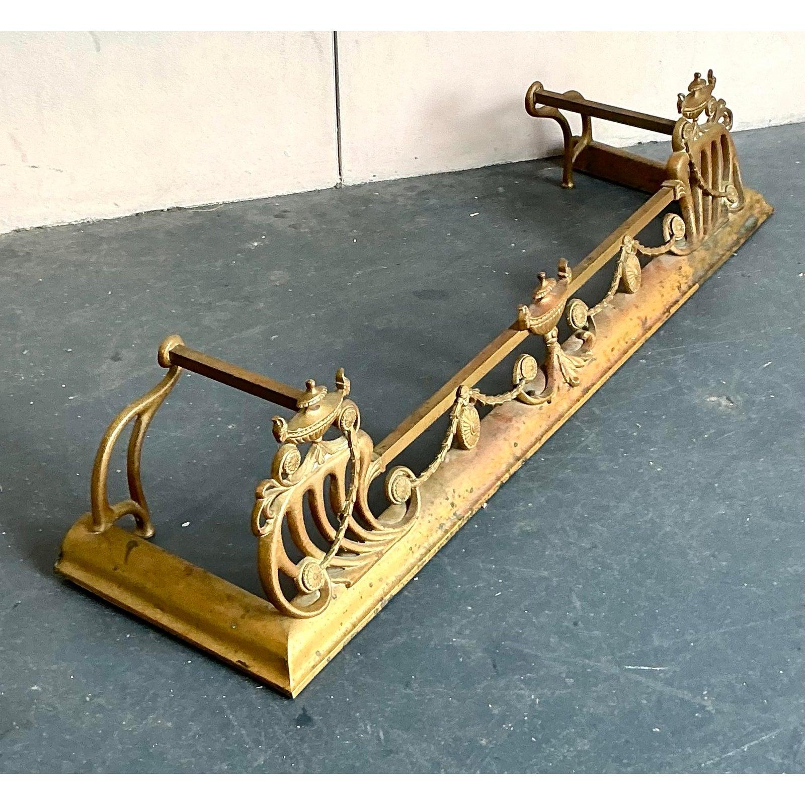 Incornicia il tuo focolare con la grandezza senza tempo di questo parafuoco vintage in stile Hollywood Regency. Realizzato con maestria in ottone caldo e ricco, questo pezzo presenta dettagli eccezionali, dalle delicate ghirlande di fiori ai motivi