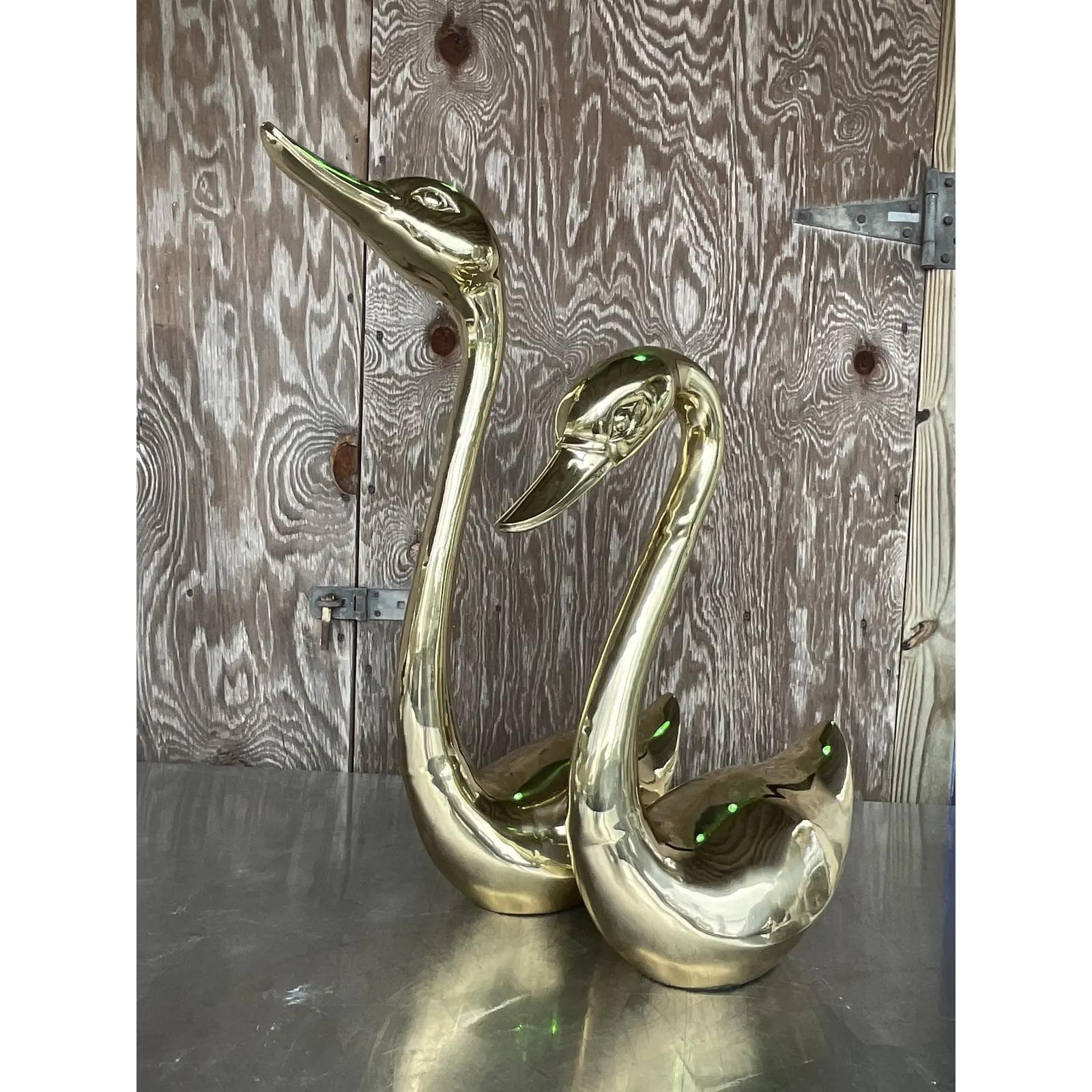 Vintage pair of vintage Regency brass swans. Beautiful long necks in a clean design. Acquired from a Palm Beach estate. 

Taller swan dimensions 20x7.5x27.25.