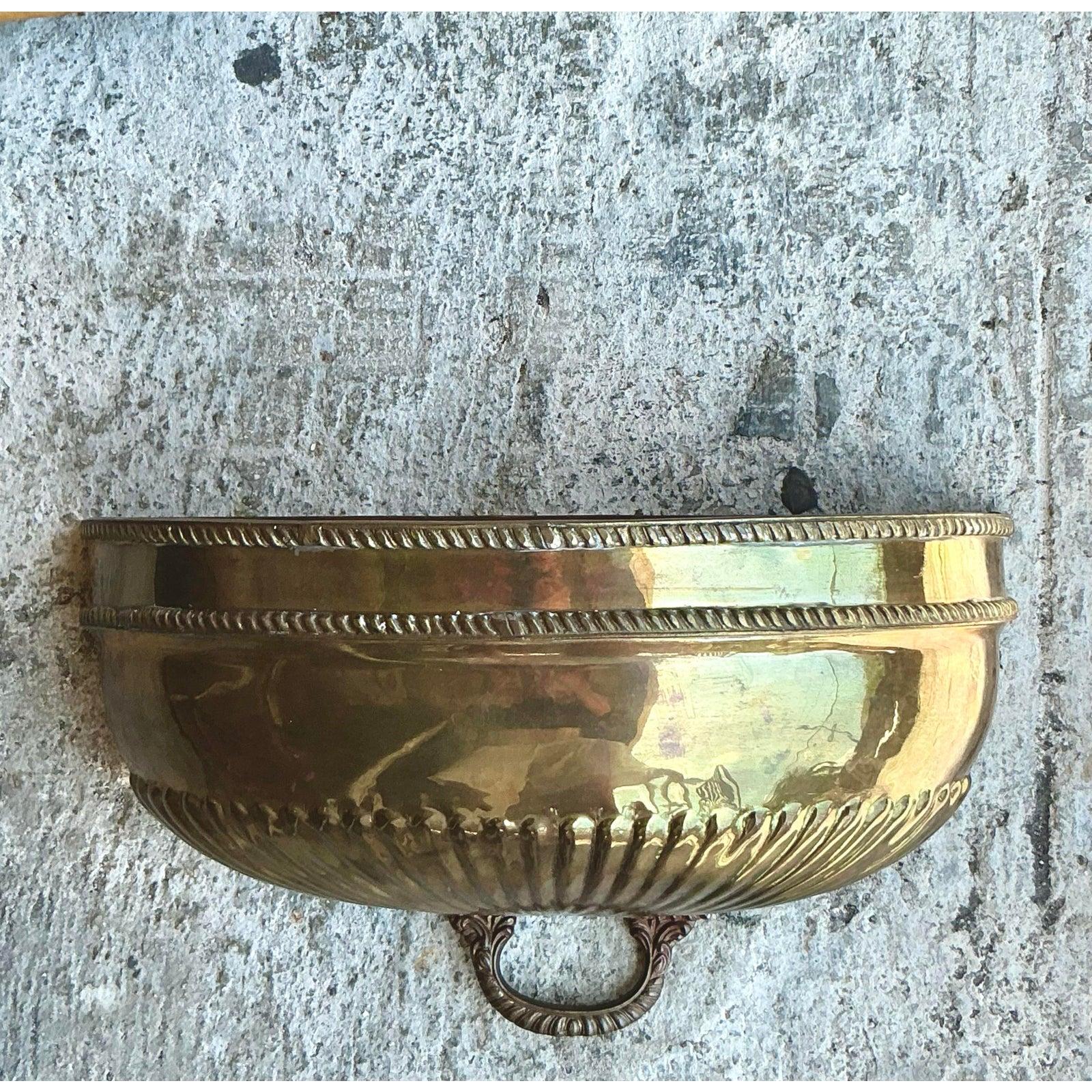Ajoutez une touche d'élégance majestueuse à votre intérieur avec cette pochette murale en laiton Vintage Regency. Avec sa forme gracieuse inspirée d'un coquillage, ses détails complexes en corde et sa patine dorée, cette pièce évoque le charme et le
