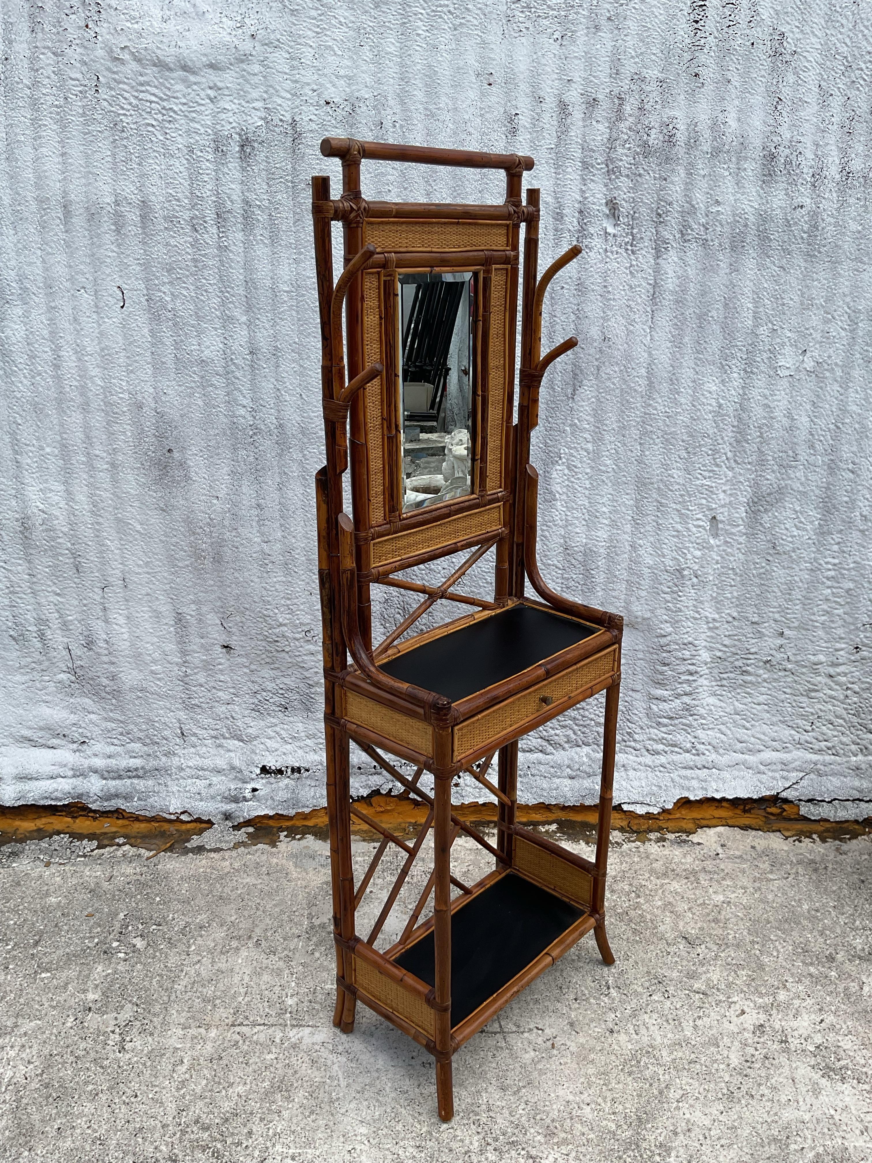 A fabulous vintage Regency hall tree. Chic burnt bamboo frame with inset woven rattan panels. Lacquered top shelf and a mirror. Acquired from a Palm Beach estate