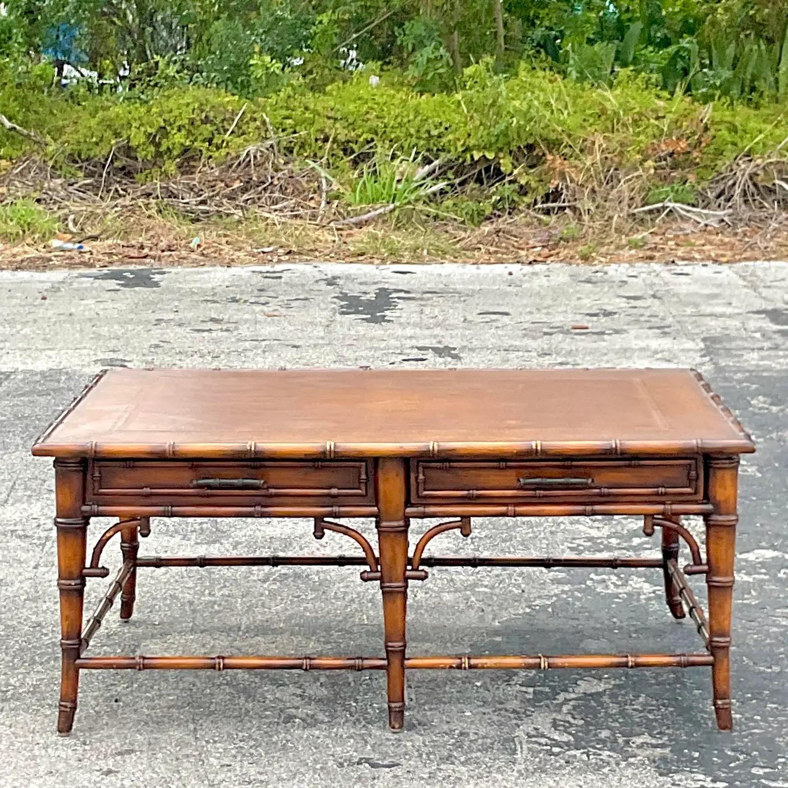A stunning vintage Coastal coffee table. A chic faux bamboo trim with a wide surface and embossed leather top. Gorgeous fretwork detail along the edge. Acquired from a Palm Beach estate.

The table is in great vintage condition. Minor scuffs and