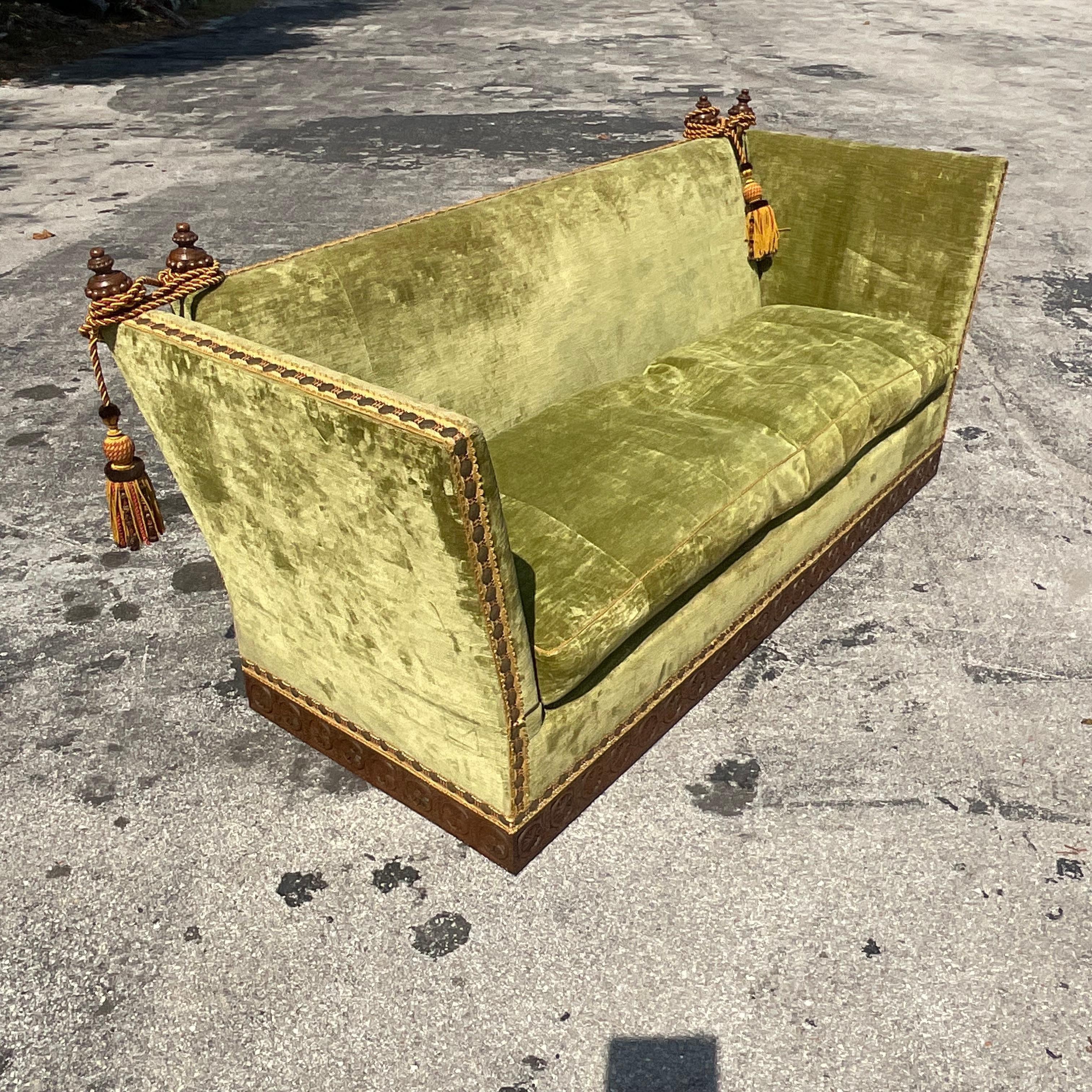 A spectacular vintage Regency Knole sofa. Made by the LA company Cache. Chic drop arm design in a brilliant chartreuse green. Heavy nailhead trim and giant tassels. Acquired from a Palm Beach estate.