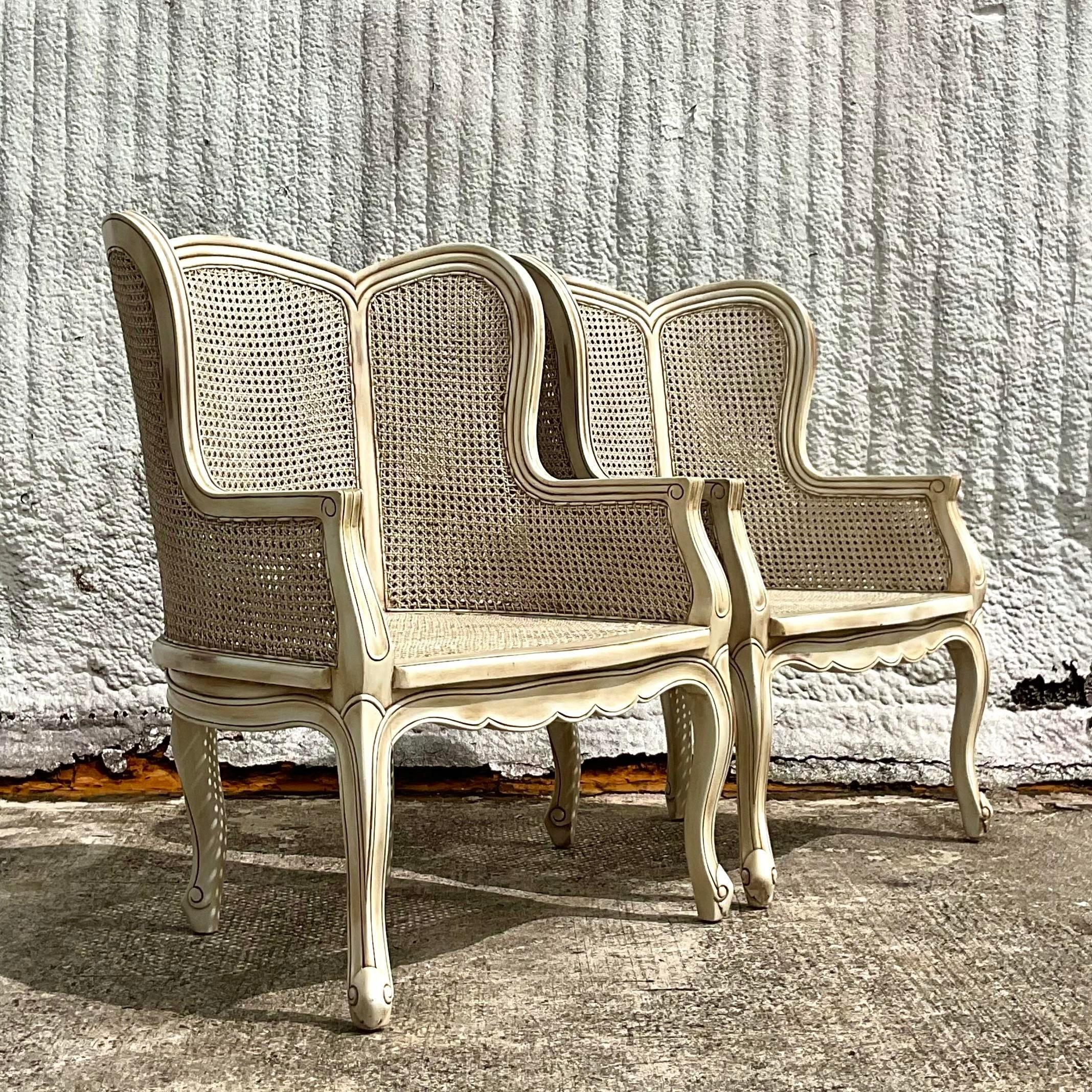 A truly beautiful pair of vintage Regency Wingback chairs. Beautiful inset cane panels embedded in a lacquered wood frame. Real showstoppers. Acquired from a Palm Beach estate.