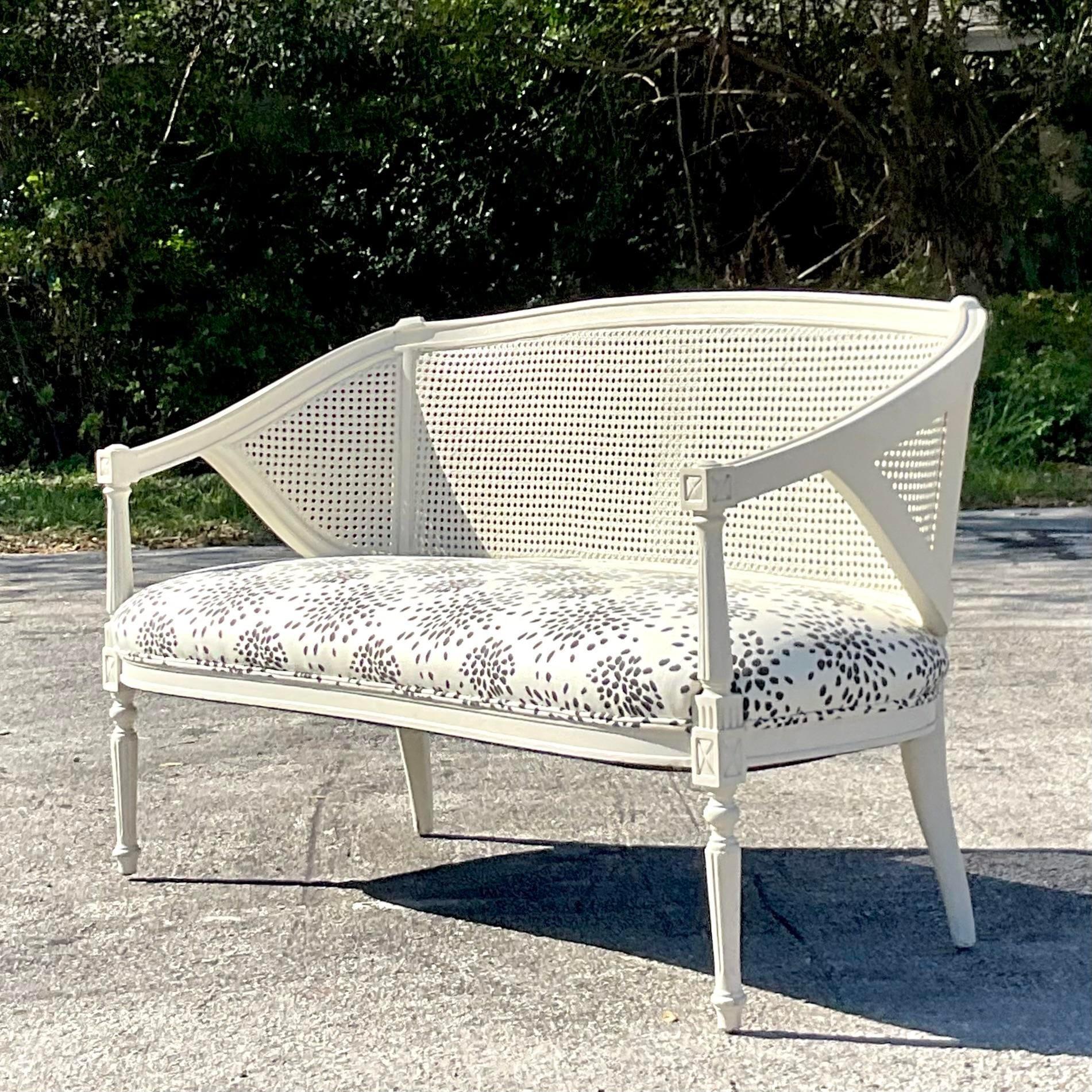 A stunning vintage Regency Settee. A chic cane back frame with the most beautiful Albert Hadley “Fireworks” upholstery. A gorgeous graphic statement. Acquired from a Beautiful Palm Beach home.