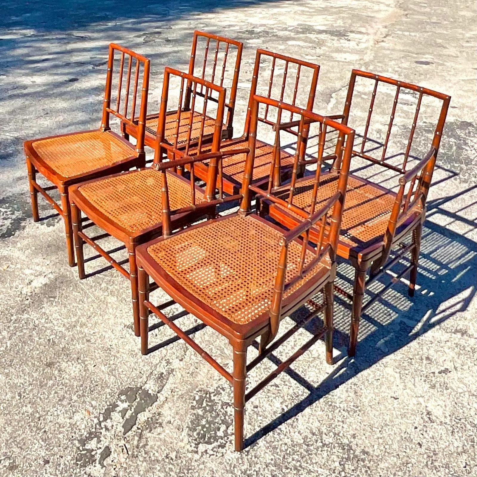 A fantastic set of six vintage Regency dining chairs. Beautiful carved bamboo frame with inset cane seats. Two arm chairs and four sides. Acquired from a Palm Beach estate.