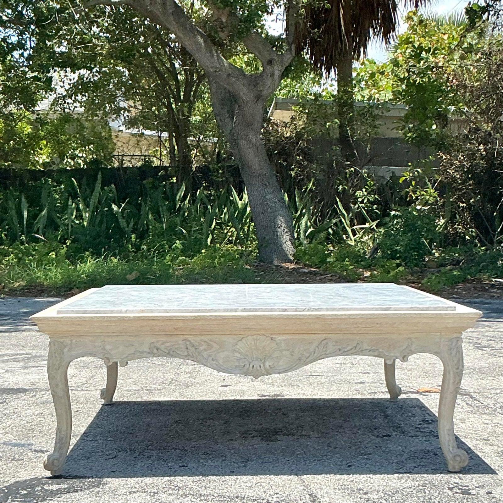 Commanding attention with its opulent design, this vintage Regency carved clamshell stone top coffee table is a true masterpiece of classic elegance. Featuring a substantial square top crafted from genuine, beautifully veined marble, it offers a