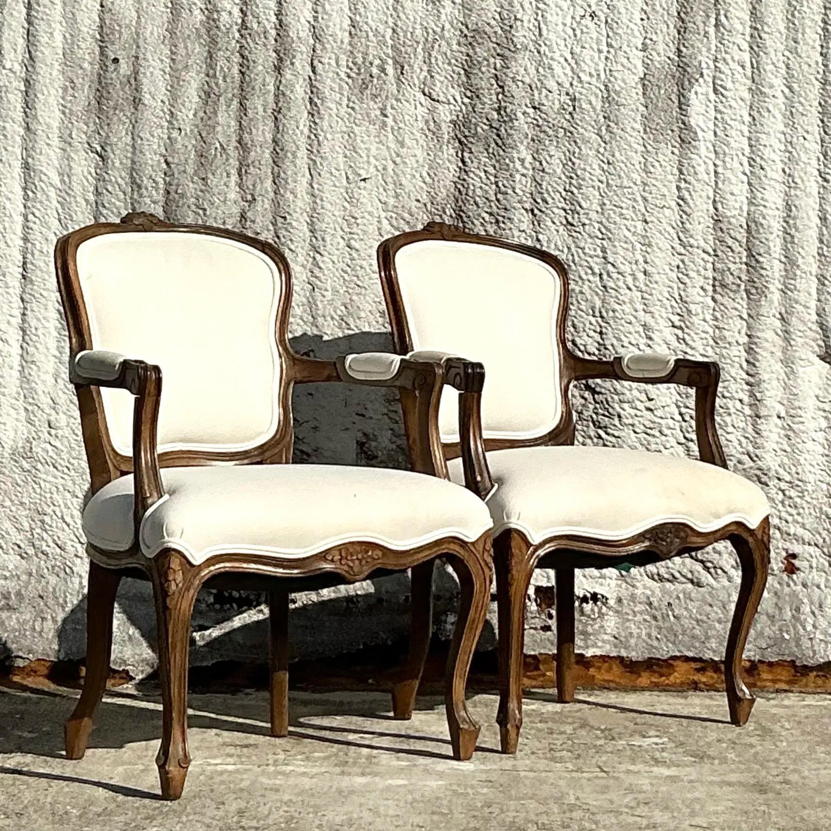 Una lussuosa coppia di sedie vintage Regency intagliate a fauteuil, che mostrano un'intricata lavorazione del legno e curve aggraziate. Con la loro struttura elegantemente scolpita e le sedute imbottite, queste sedie fondono la raffinatezza classica
