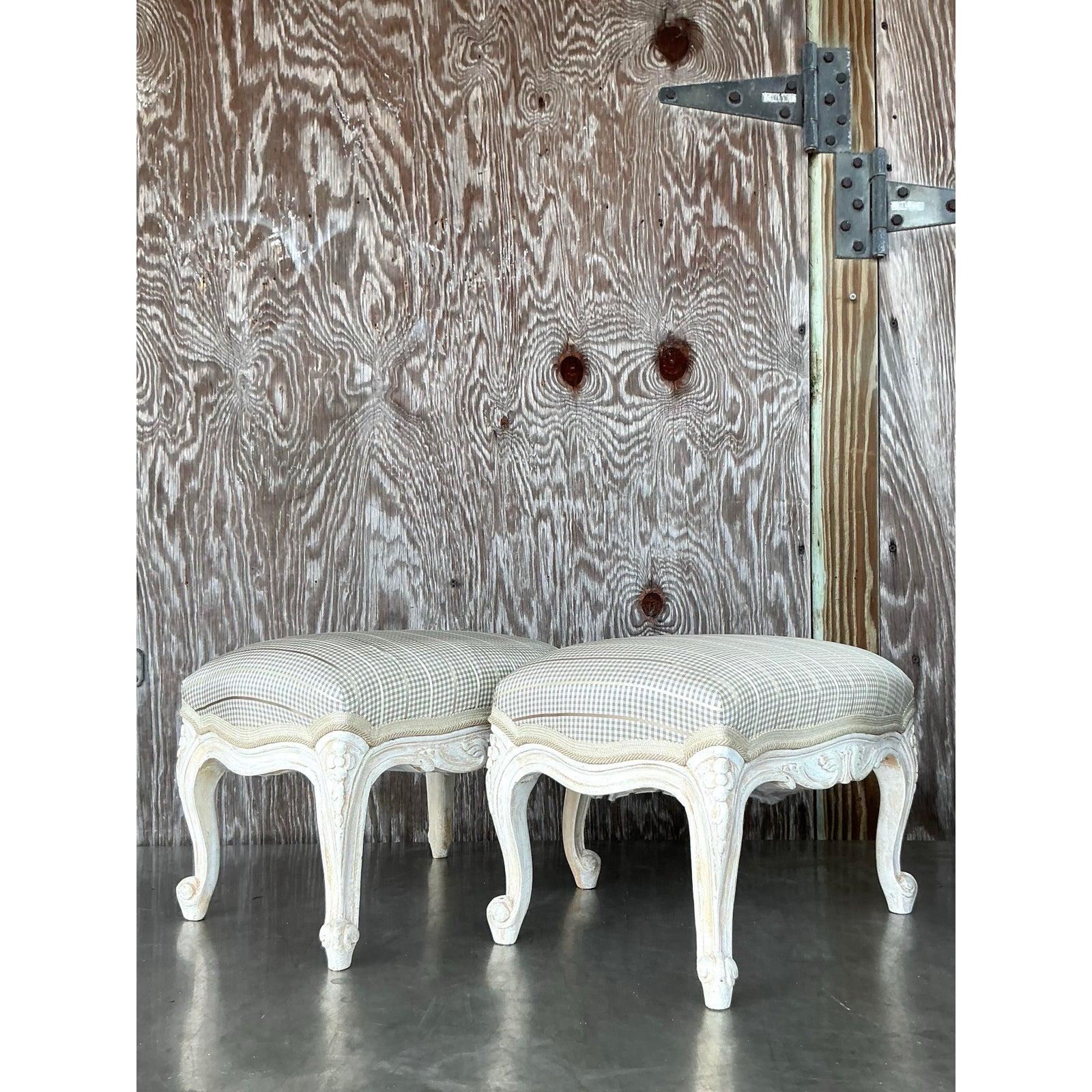 Élevez votre espace avec cette paire exquise de poufs Vintage Regency sculptés, où l'élégance intemporelle rencontre un savoir-faire impeccable. Chaque pouf est doté de pieds cabriole sculptés de manière complexe dans une douce finition crème,