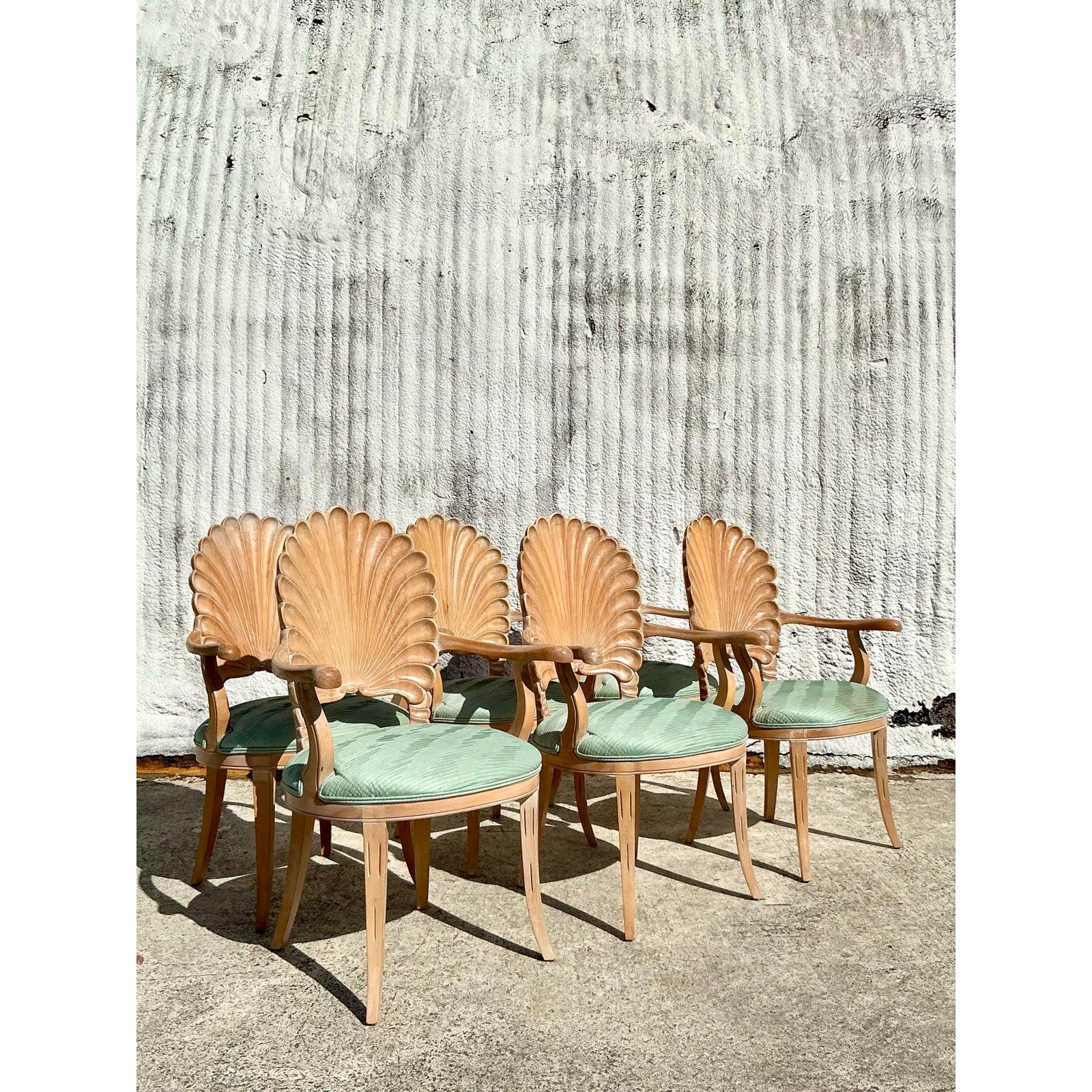 Elevate your dining space with this stunning set of six vintage carved grotto dining chairs, featuring exquisite shell-inspired backs and elegantly curved armrests. These sculptural chairs blend coastal charm with Regency sophistication, making them