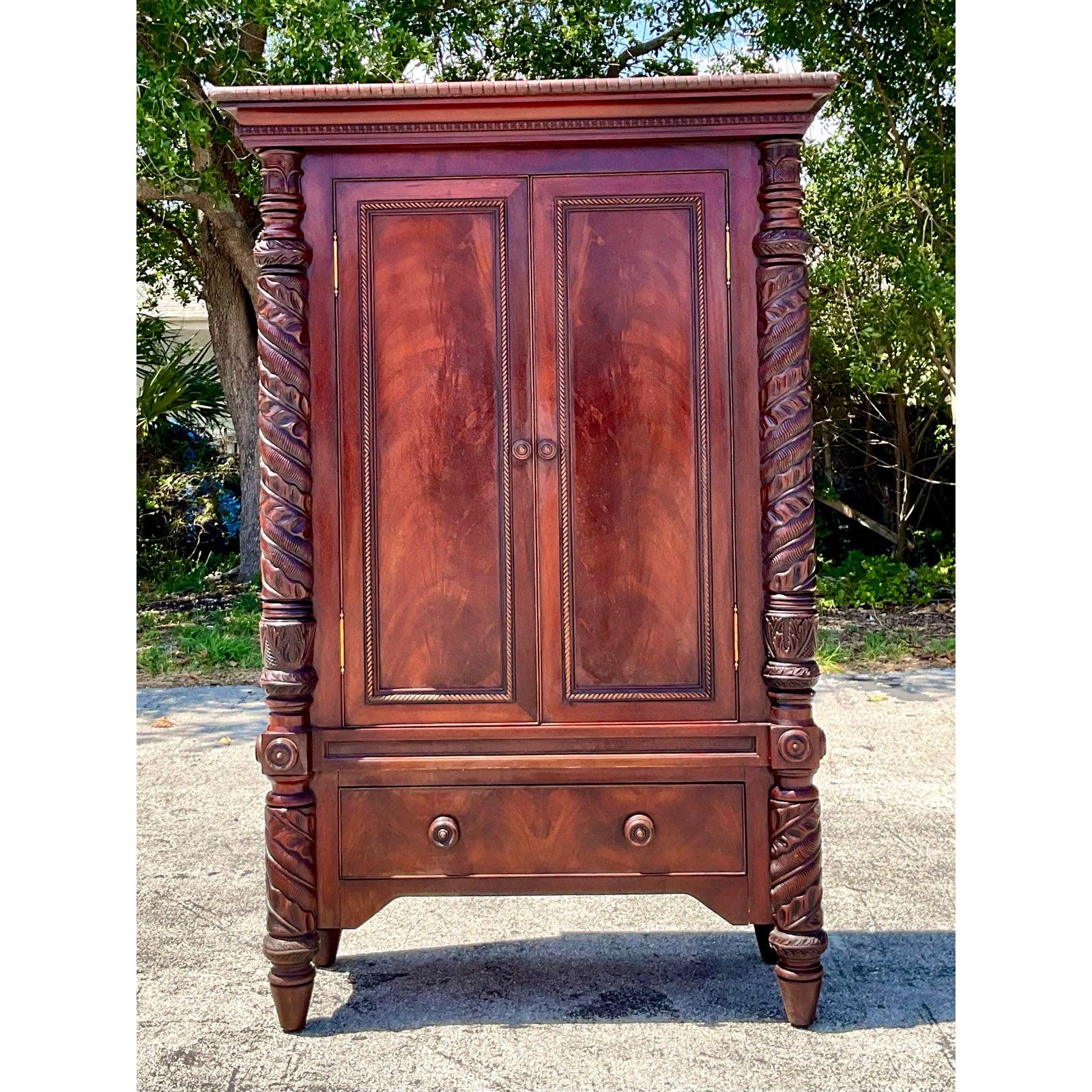 Rehaussez votre intérieur avec cette exquise armoire Vintage Regency en acajou sculpté - une véritable déclaration d'artisanat et de charme historique. Avec ses colonnes torsadées, ses portes à panneaux biseautés et son placage d'acajou richement