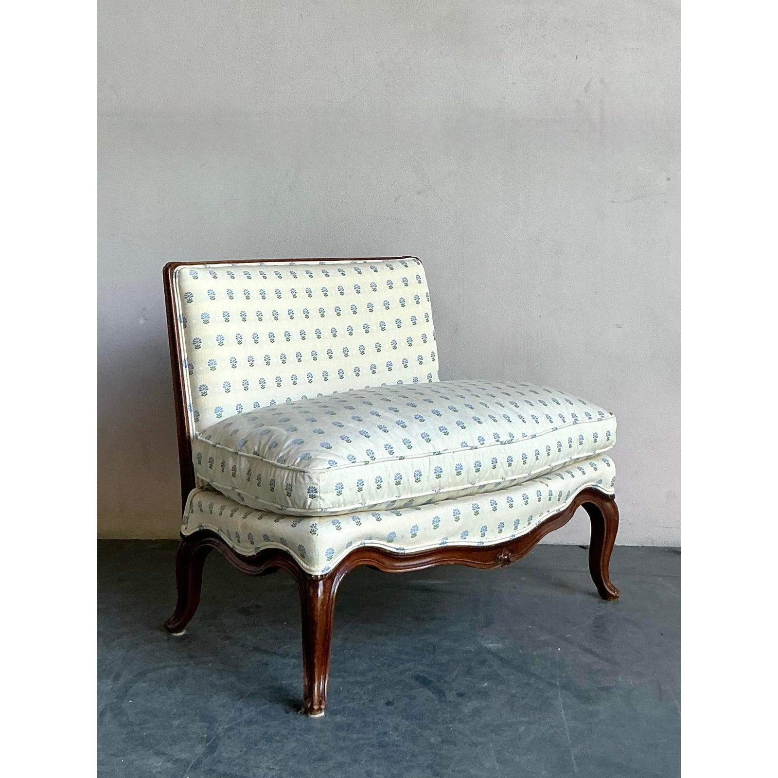Un pezzo di puro romanticismo e charme, questa sedia a pantofola vintage cattura perfettamente l'eleganza dello stile provinciale francese. La splendida struttura in legno a vista presenta un fronte graziosamente serpeggiante e classiche gambe a