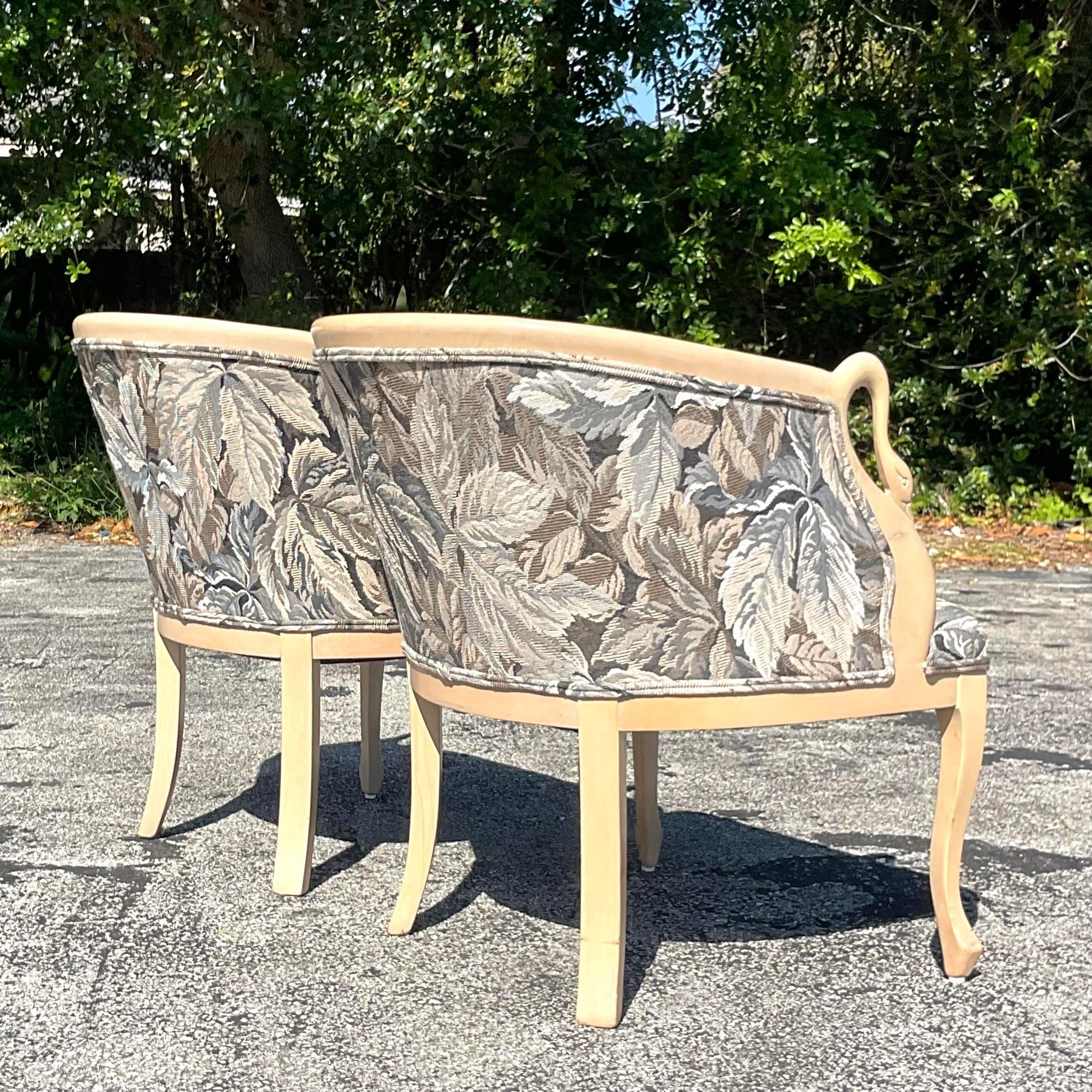 Eleganza e grazia del design classico americano con questa coppia di sedie da salotto vintage Regency con testa di cigno intagliata. Realizzate con dettagli squisiti e ispirate a motivi regali senza tempo, queste sedie trasudano raffinatezza e