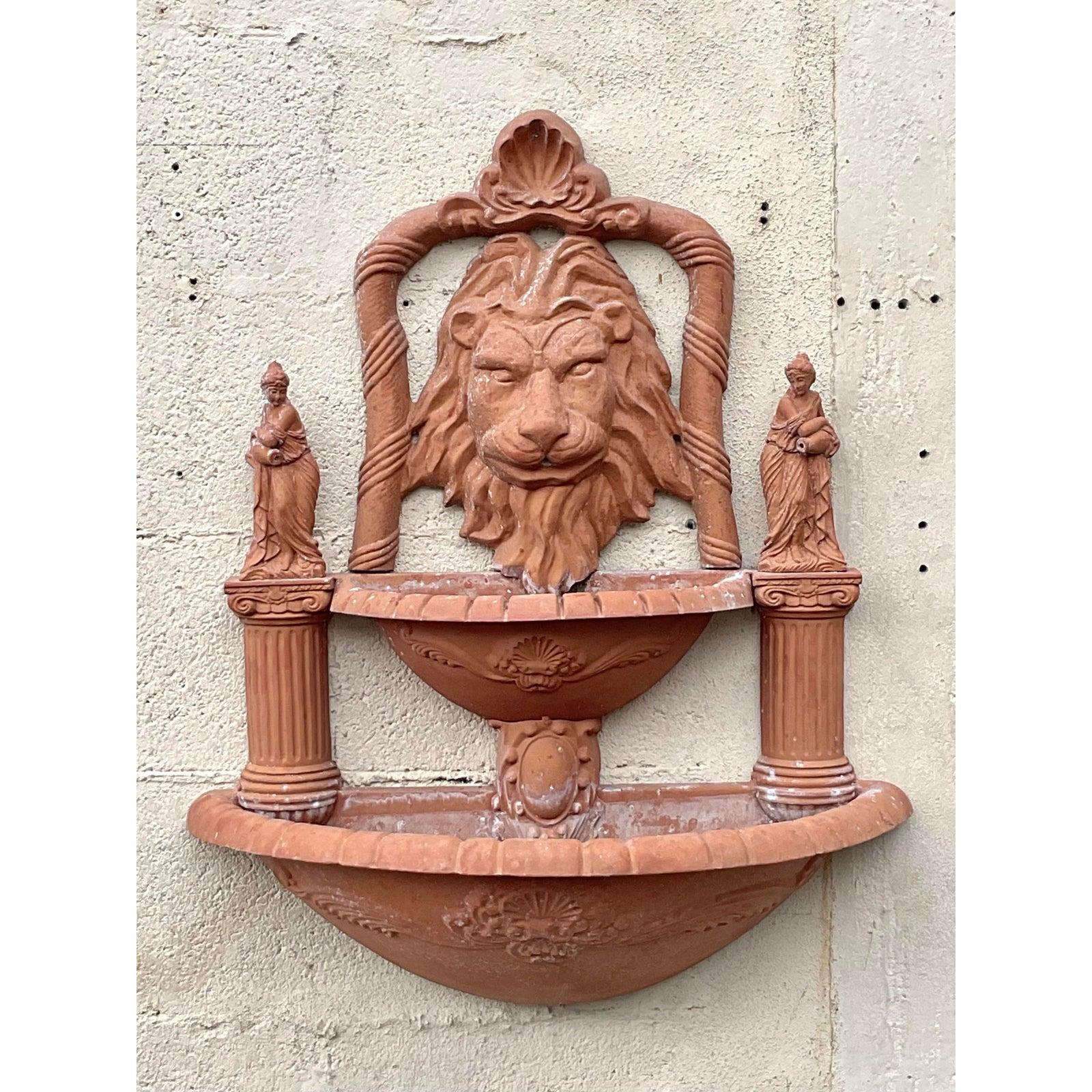Attirez l'attention avec cette fontaine murale tête de lion Vintage Regency, un accent architectural captivant fabriqué en aluminium moulé avec une finition classique en terre cuite. Avec son visage de lion féroce et noble flanqué de colonnes