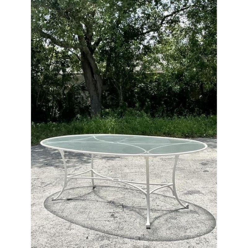Elevate your outdoor living with this stunning vintage Hollywood Regency dining table, designed to host grand gatherings in style. Crafted from durable cast aluminum, it features a graceful, expansive oval silhouette supported by elegant, curved