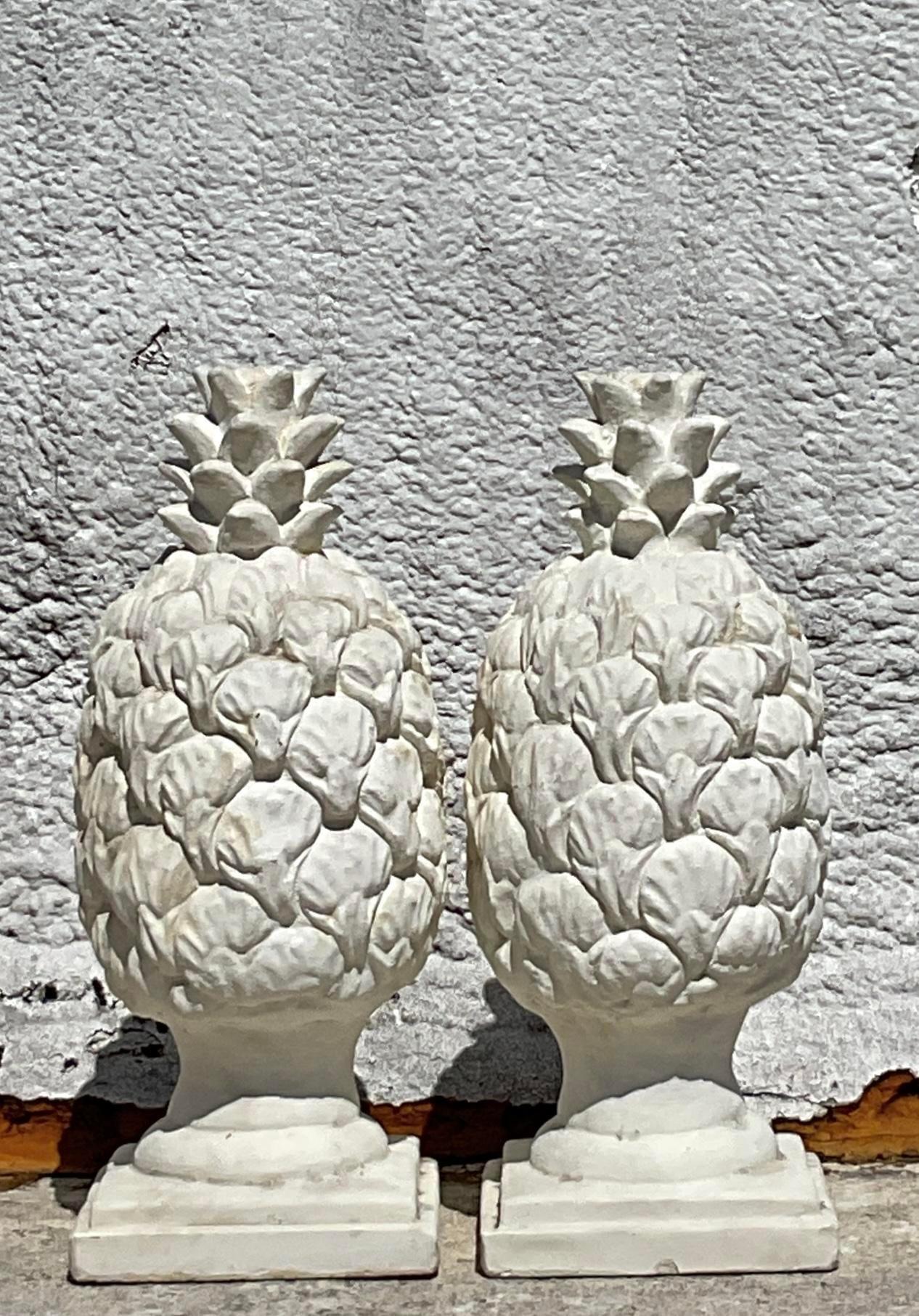 Add a touch of Americana charm to your outdoor space with this pair of vintage Regency cast concrete pineapple statues. Symbolizing hospitality and warmth, these timeless pieces evoke the classic allure of traditional American design, perfect for
