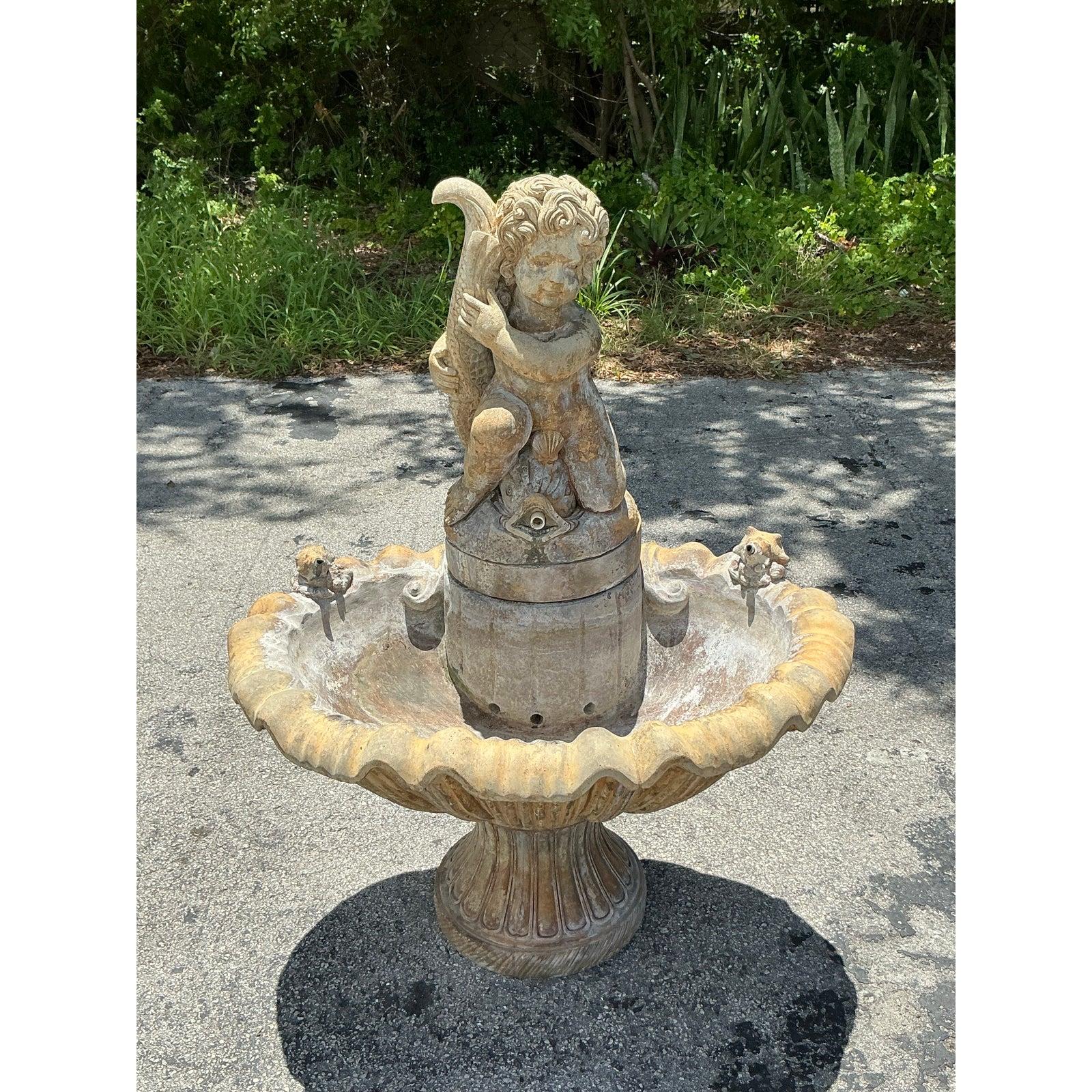 Transform your garden into a timeless European oasis with this magnificent vintage cast stone fountain. Drawing inspiration from Neoclassical and Italianate design, this water feature is a work of art, centered around a charmingly sculpted cherub
