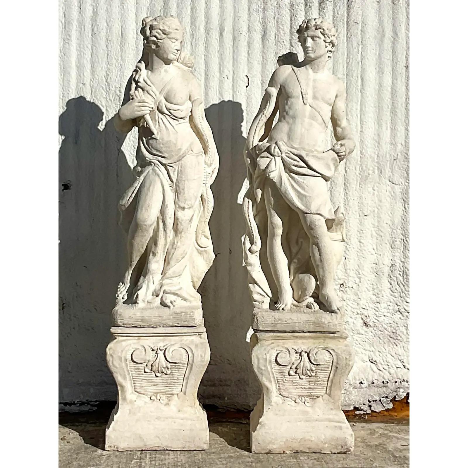 A spectacular pair of vintage Regency statues. A chic pair of mythological figure done in a cast stone. Each rests on a detailed plinth. Perfect indoors or outside. Acquired from a Palm Beach estate.