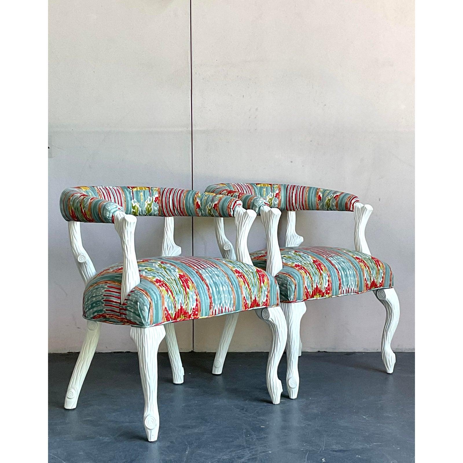A stunning display of Hollywood Regency glamour, this exquisite pair of lounge chairs makes an unforgettable statement. The frames are artfully carved in a whimsical faux bois style, mimicking the organic form of tree branches finished in an elegant