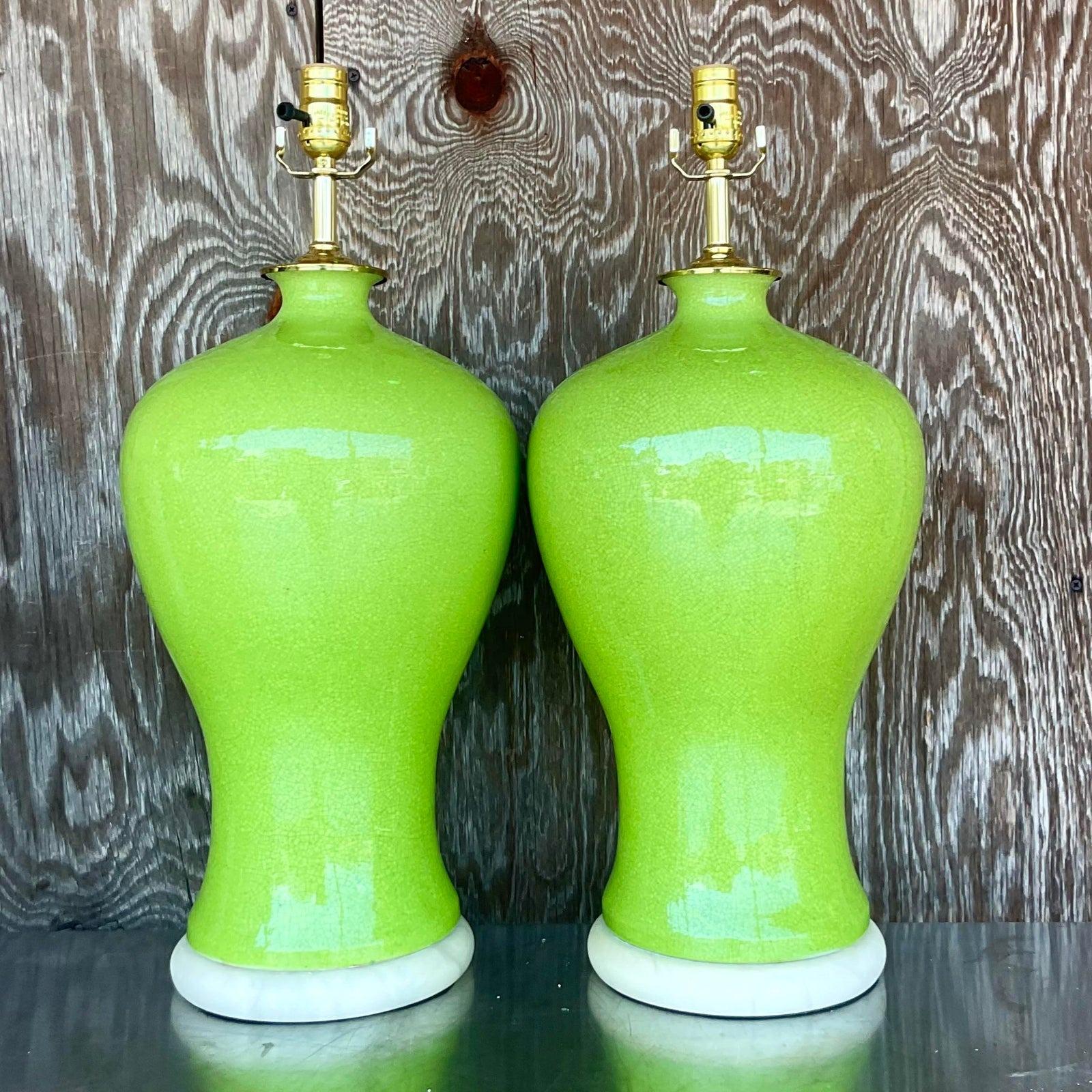 A fabulous pair of vintage Regency table lamps. A brilliant Apple green urn shape in a crackle glaze finish. Rest on an incredible pair of vintage solid Alabaster plinths. Fully restored with all new wiring and hardware. Acquired from a Palm Beach