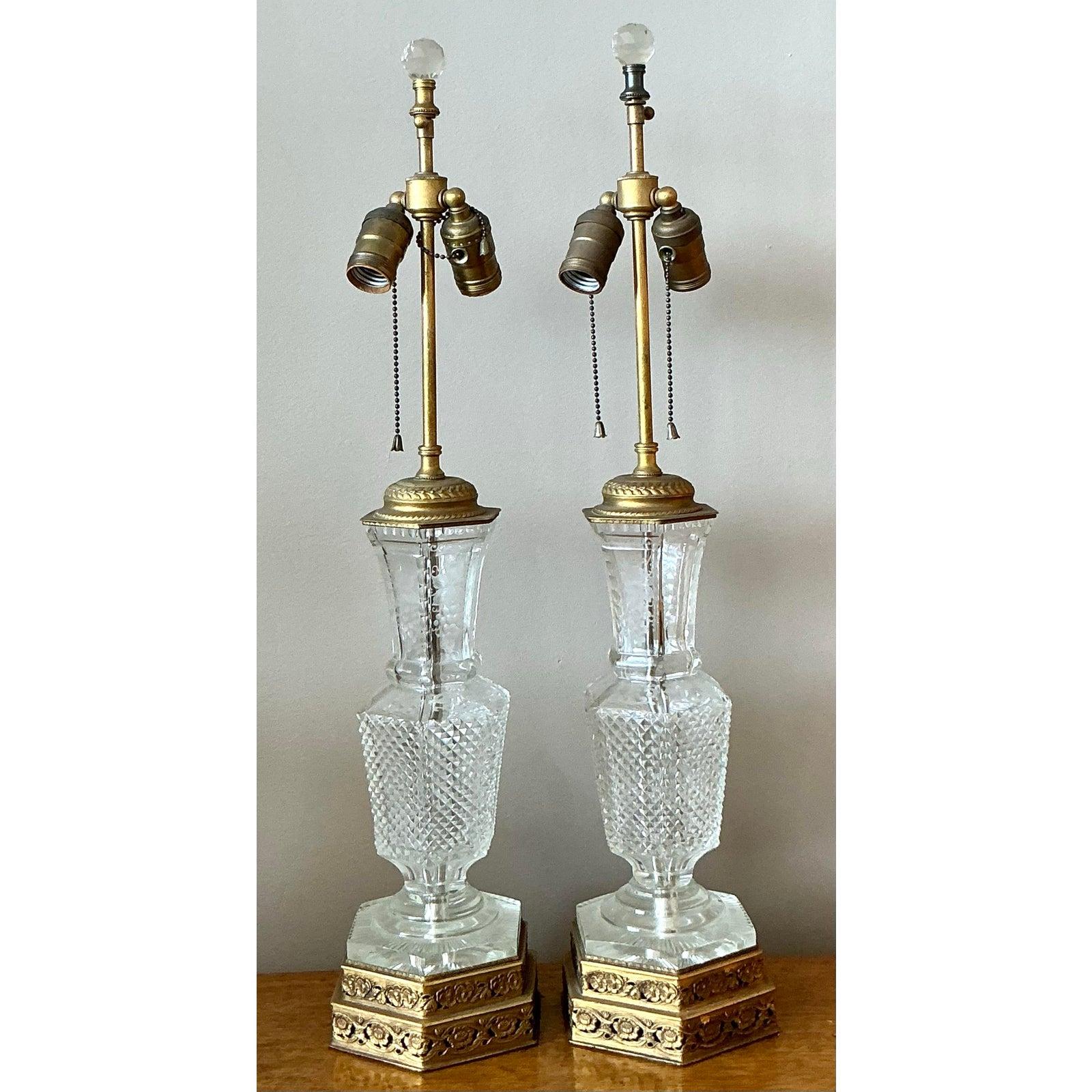 Illuminate your home with the timeless elegance of this exquisite pair of vintage table lamps. Each lamp features a beautifully faceted, hexagonal crystal body that expertly catches and refracts light, creating a brilliant sparkle. This luminous
