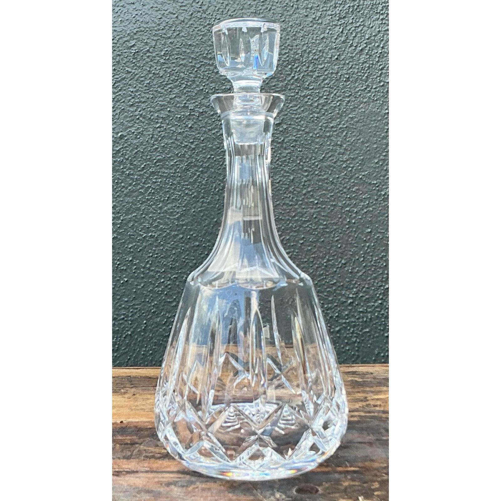 Peppen Sie Ihre Hausbar mit dieser schillernden Karaffe in geschliffenem Vintage-Kristall auf, die den raffinierten Glanz der Hollywood-Regency-Ära perfekt einfängt. Das Gefäß hat einen klassischen bauchigen Sockel, der mit einem brillanten