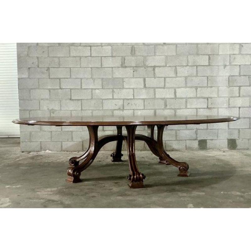 Questo monumentale tavolo da pranzo d'epoca ripropone la grandezza del design tradizionale Regency e Impero, rendendolo un punto focale spettacolare per una sala da pranzo formale o uno spazio per conferenze dirigenziali. Realizzato con