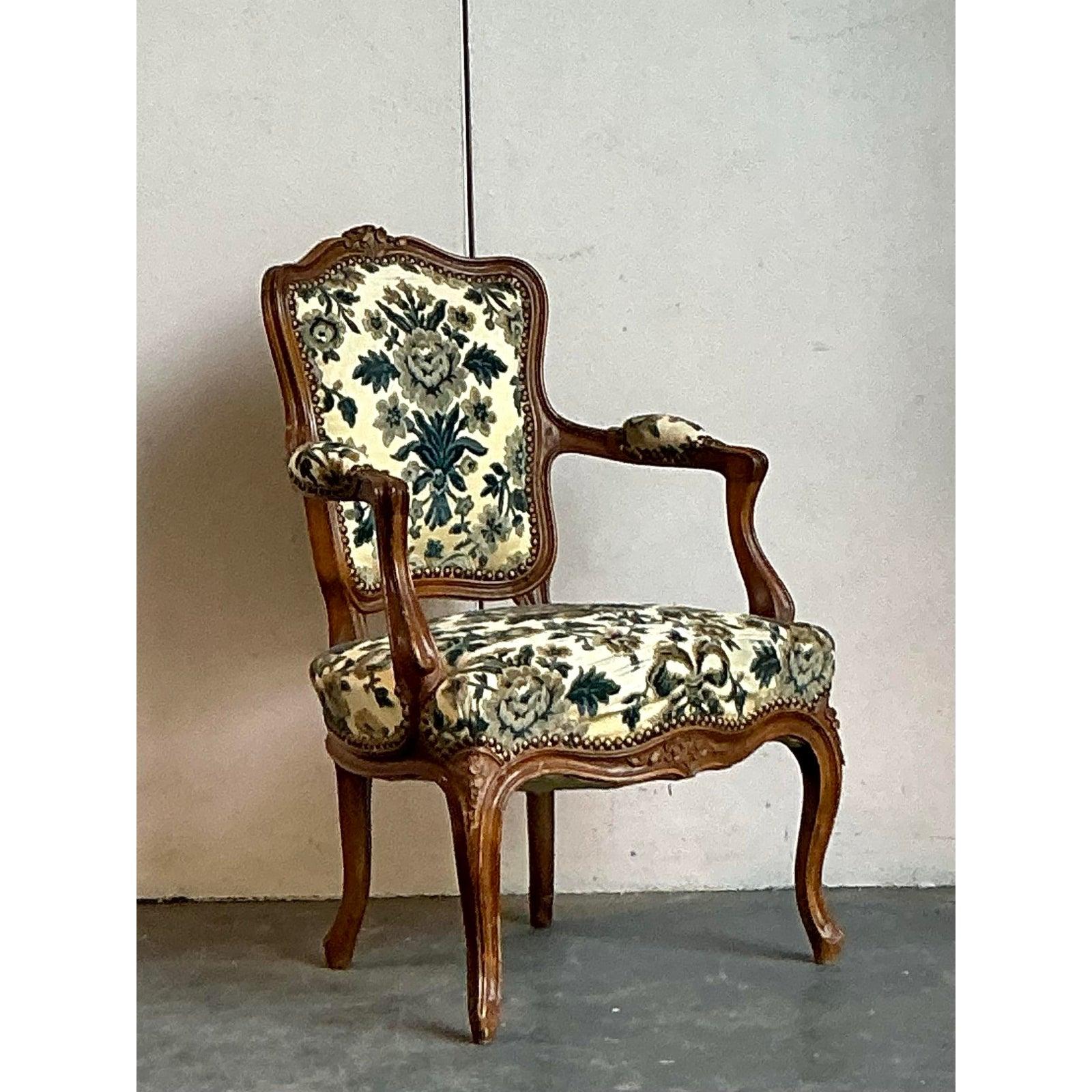 Elevate your living space with this exquisite Vintage French Regency Fireside Chair, a true testament to timeless design and artisanal craftsmanship. Adorned with a charming distressed Fleur de Lys upholstery, this chair captures the essence of