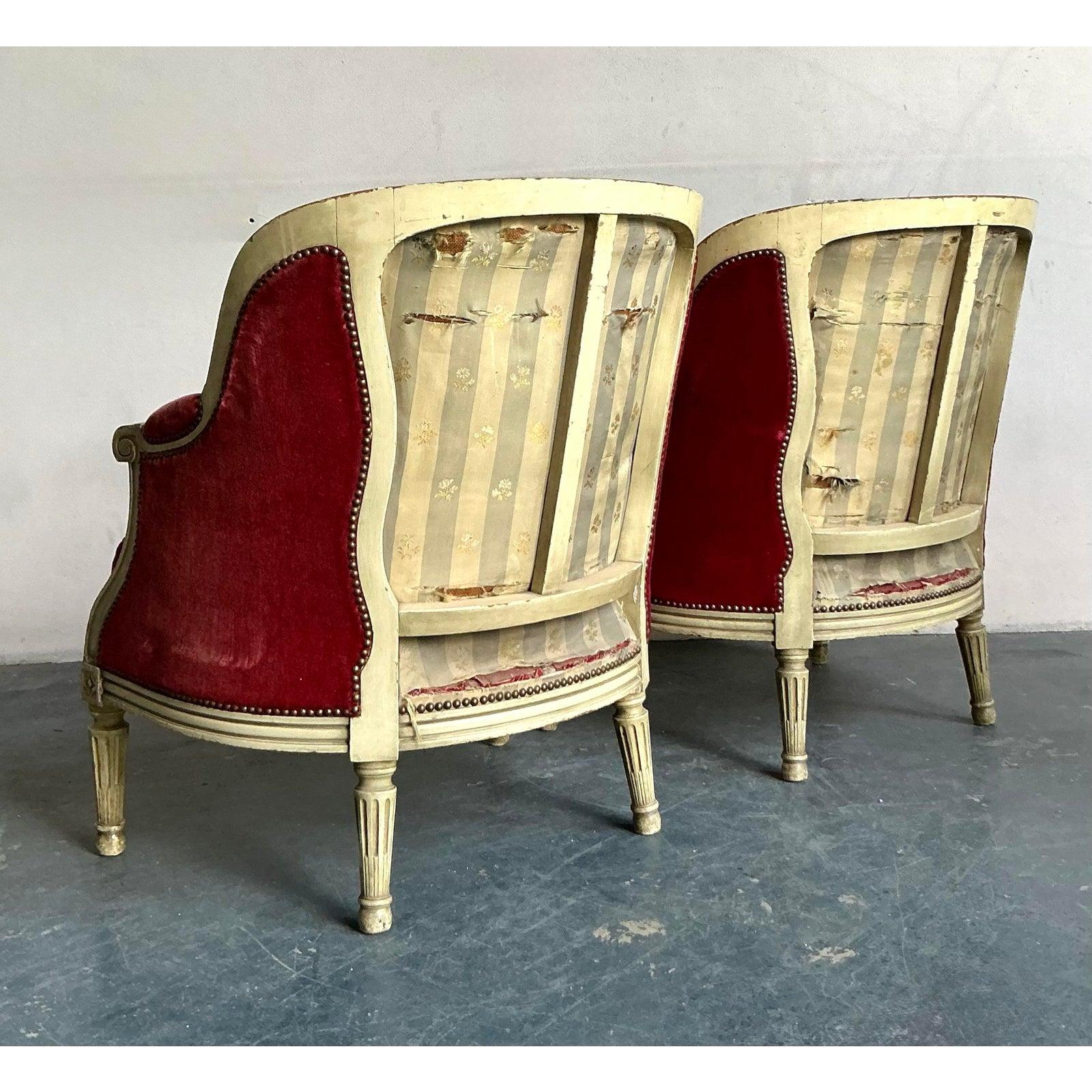 Questa squisita coppia di poltrone bergère emana la classica eleganza francese, caratterizzata dalle linee pulite e dai dettagli raffinati tipici dello stile Luigi XVI. Ogni sedia è incorniciata da un legno finemente intagliato, rifinito con una