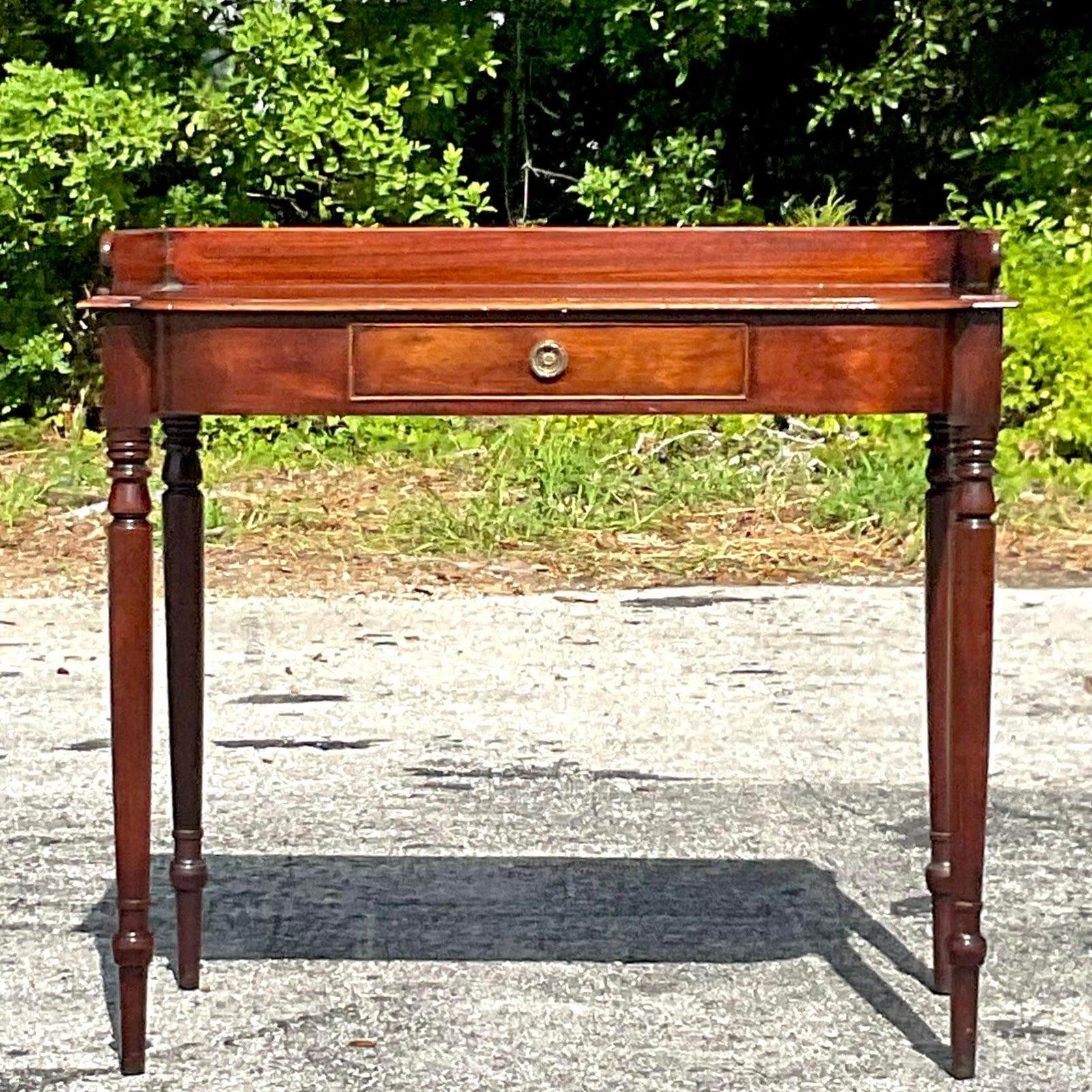A fabulous vintage Regency writing desk. A beautiful English Mahogany style with long slender legs. Acquired from a Palm Beach estate.