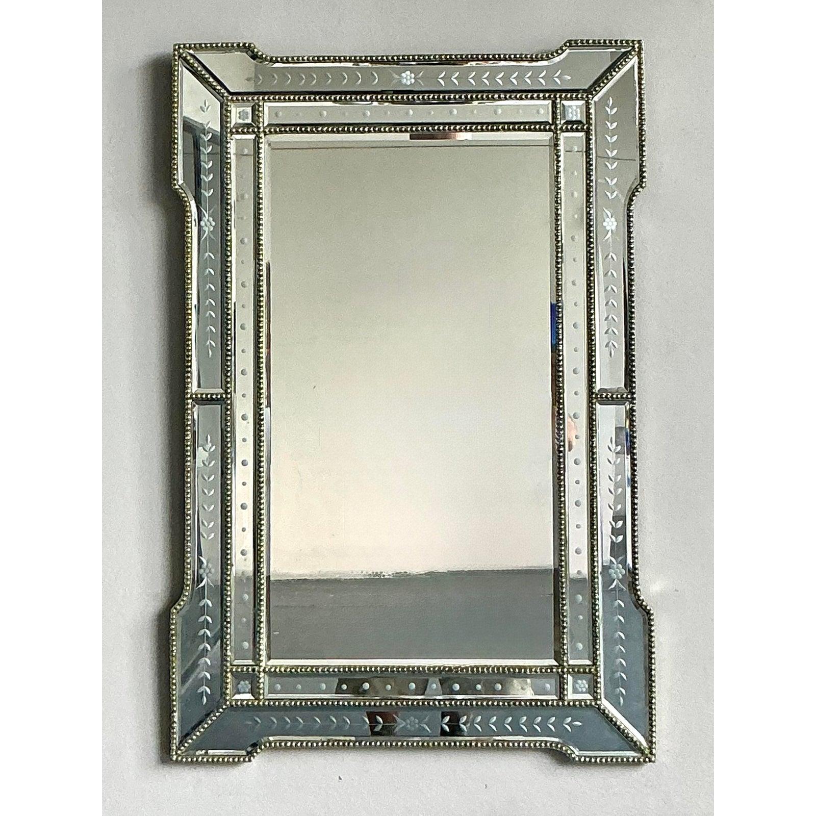 Ornez vos murs avec le glamour intemporel de ce miroir en verre gravé vintage Hollywood Regency. Cette pièce opulente présente un cadre méticuleusement travaillé composé de panneaux individuels en verre gravé, chacun orné d'élégants motifs floraux