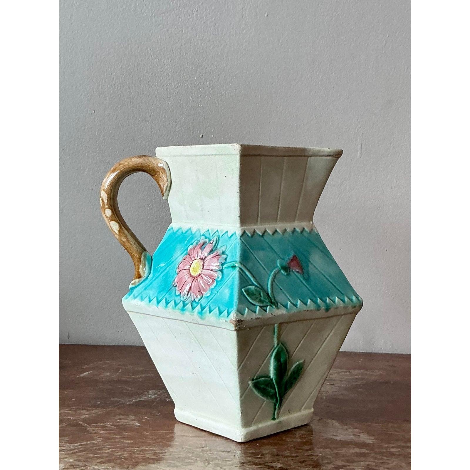 A striking and highly unusual piece of Victorian ceramic art, this antique majolica pitcher is a wonderful example of the Aesthetic Movement. The design features a bold, architectural form with faceted, angular sides that create a dynamic, geometric