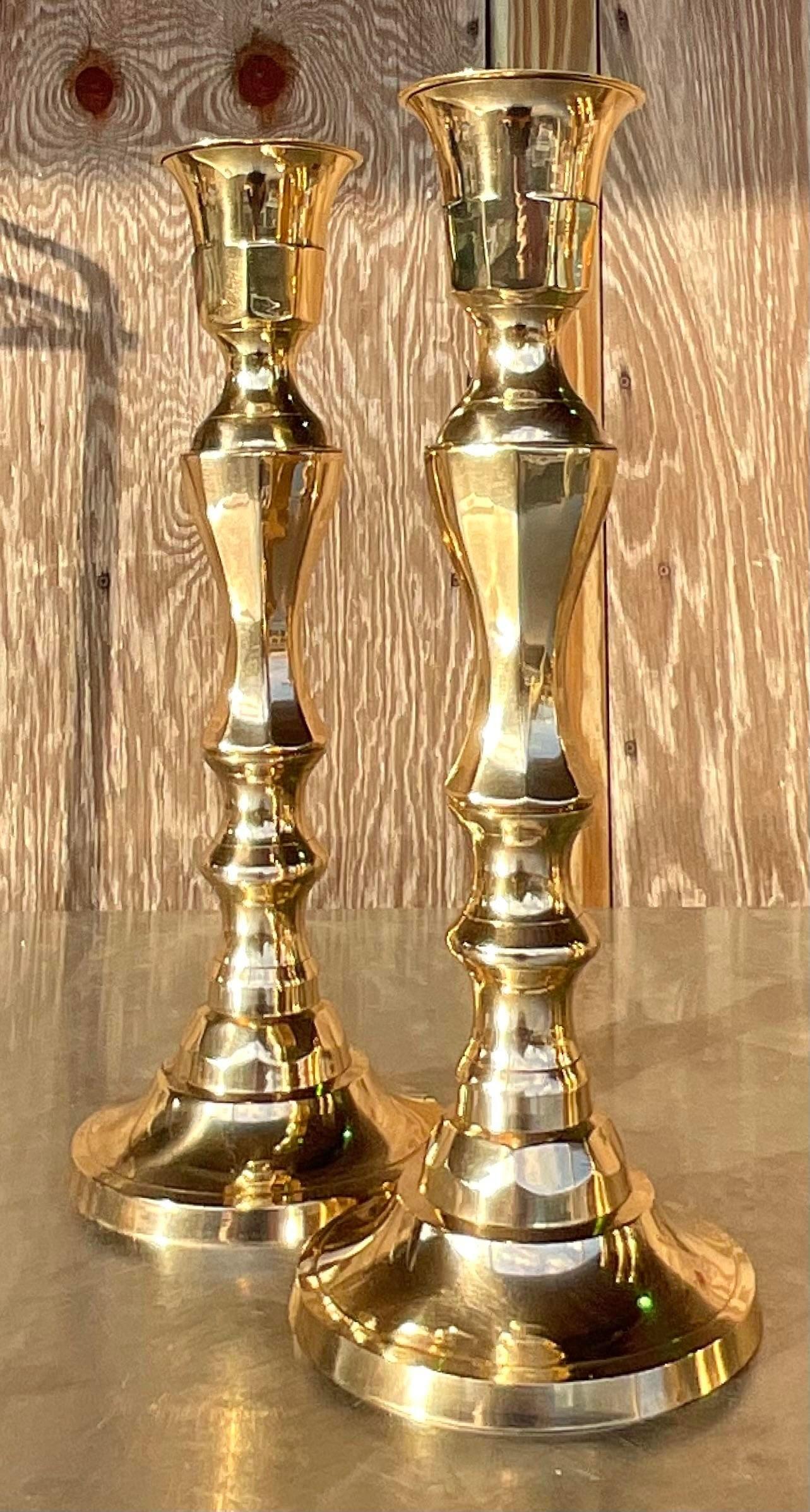 A sensational pair of vintage Regency candlesticks. Beautiful mirror polished brass with a chic faceted design. Acquired from a Palm Beach estate.