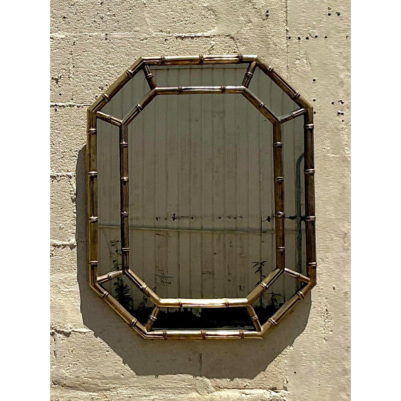 Trasmetti un'eleganza senza tempo con questo specchio ottagonale in stile vintage Regency con una scultorea cornice in finto bambù in una ricca finitura oro antico. La silhouette geometrica abbinata al motivo del bambù crea una sofisticata miscela