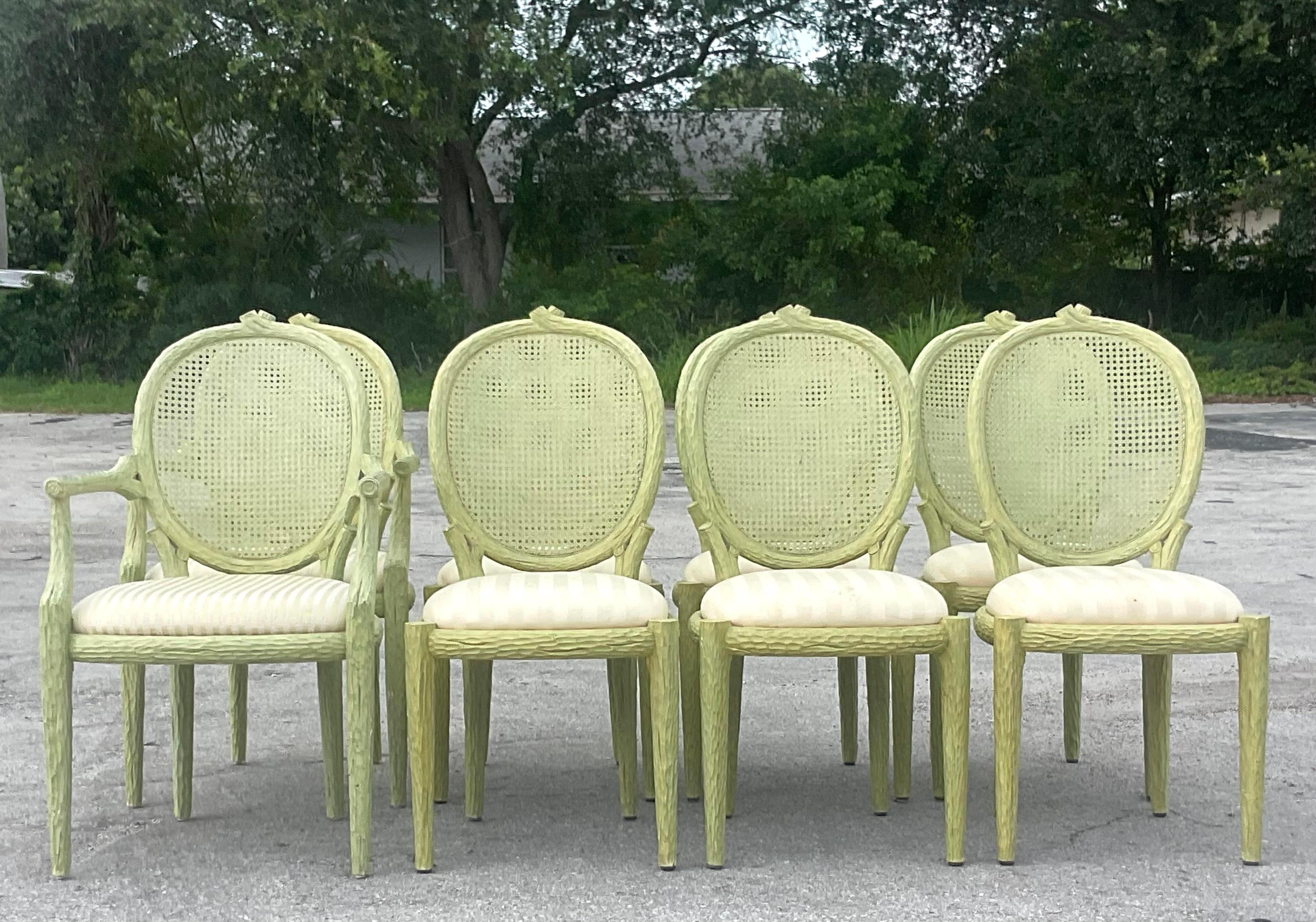 A fabulous set of 8 vintage Regency dining chairs. Stunning Faux Bois frames painted the most beautiful green. Inset cane backs and upholstered cushions. Two arms chairs and six sides. Acquired from a Palm Beach estate.

Arm chairs 23x18x39