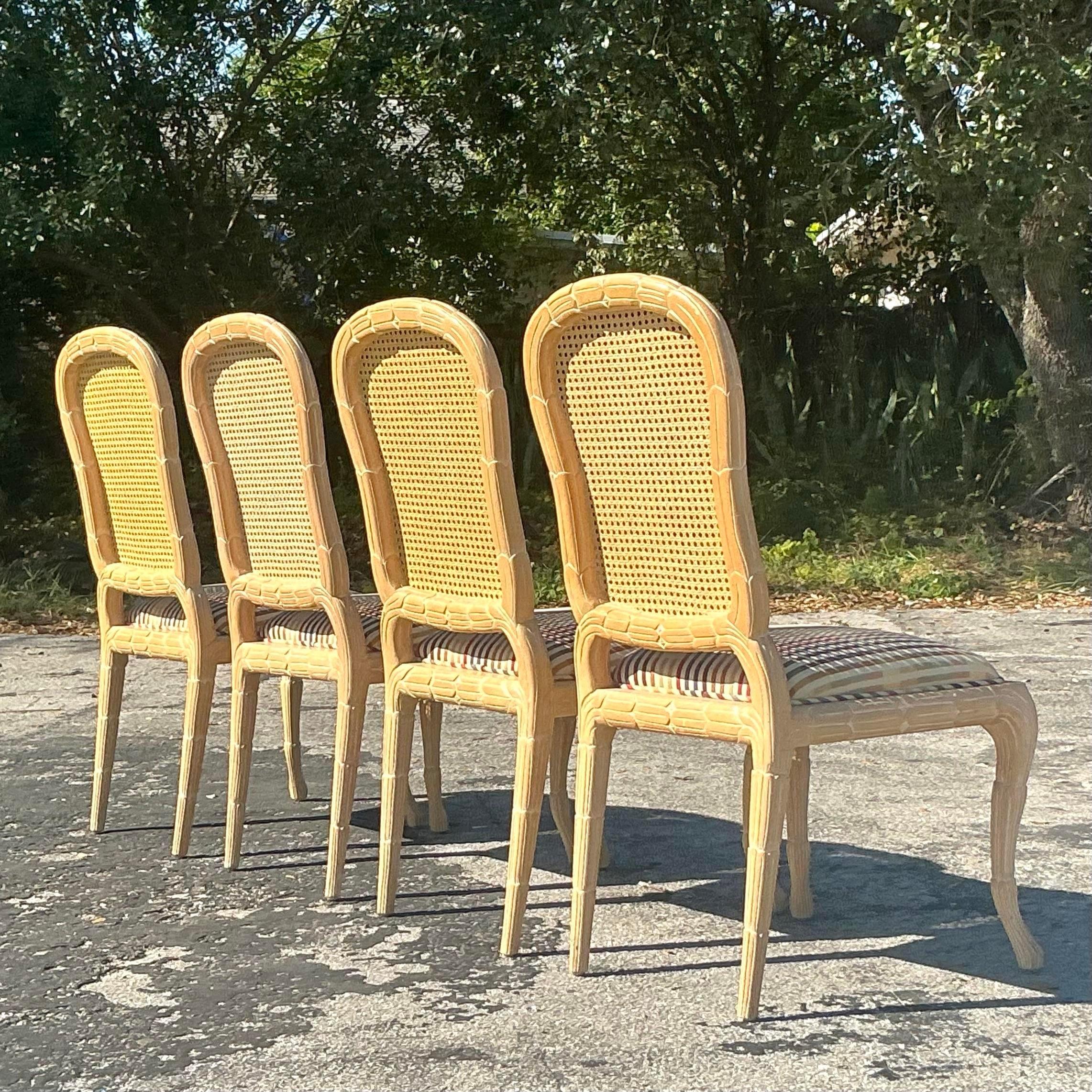 Questo set di quattro sedie da pranzo Regency vintage presenta un elegante design in faux bois abbinato al classico schienale in canna, che unisce texture naturali e stile raffinato. L'intricata finitura a finte venature del legno aggiunge