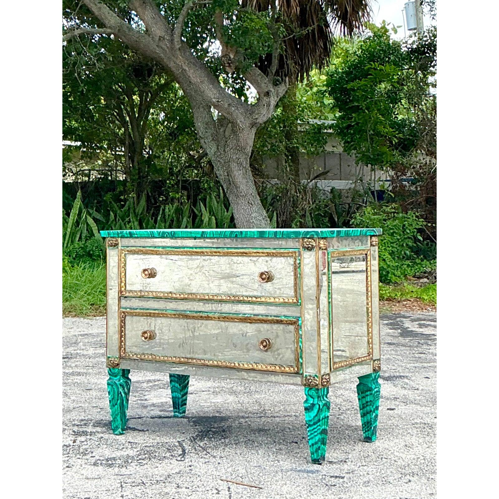 Unleash a wave of unapologetic glamour with this spectacular vintage Hollywood Regency chest. A true work of decorative art, this piece masterfully combines antiqued églomisé mirror panels with a vibrant, hand-painted faux malachite finish on its