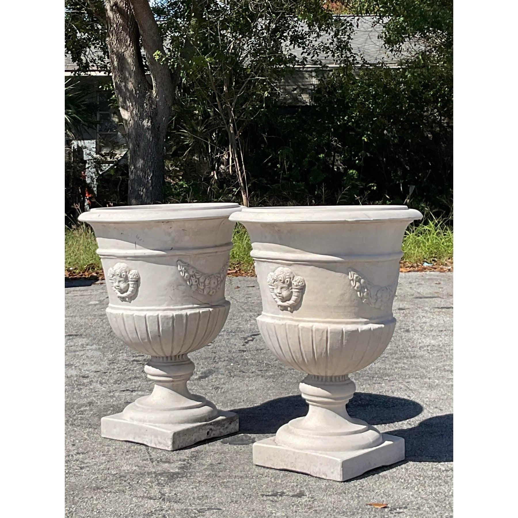 Ajoutez une touche d'élégance classique à votre espace intérieur ou extérieur avec cette superbe paire d'urnes en fibre de verre de style Regency. Conçues dans un esprit néoclassique, ces urnes présentent des détails complexes en relief, notamment