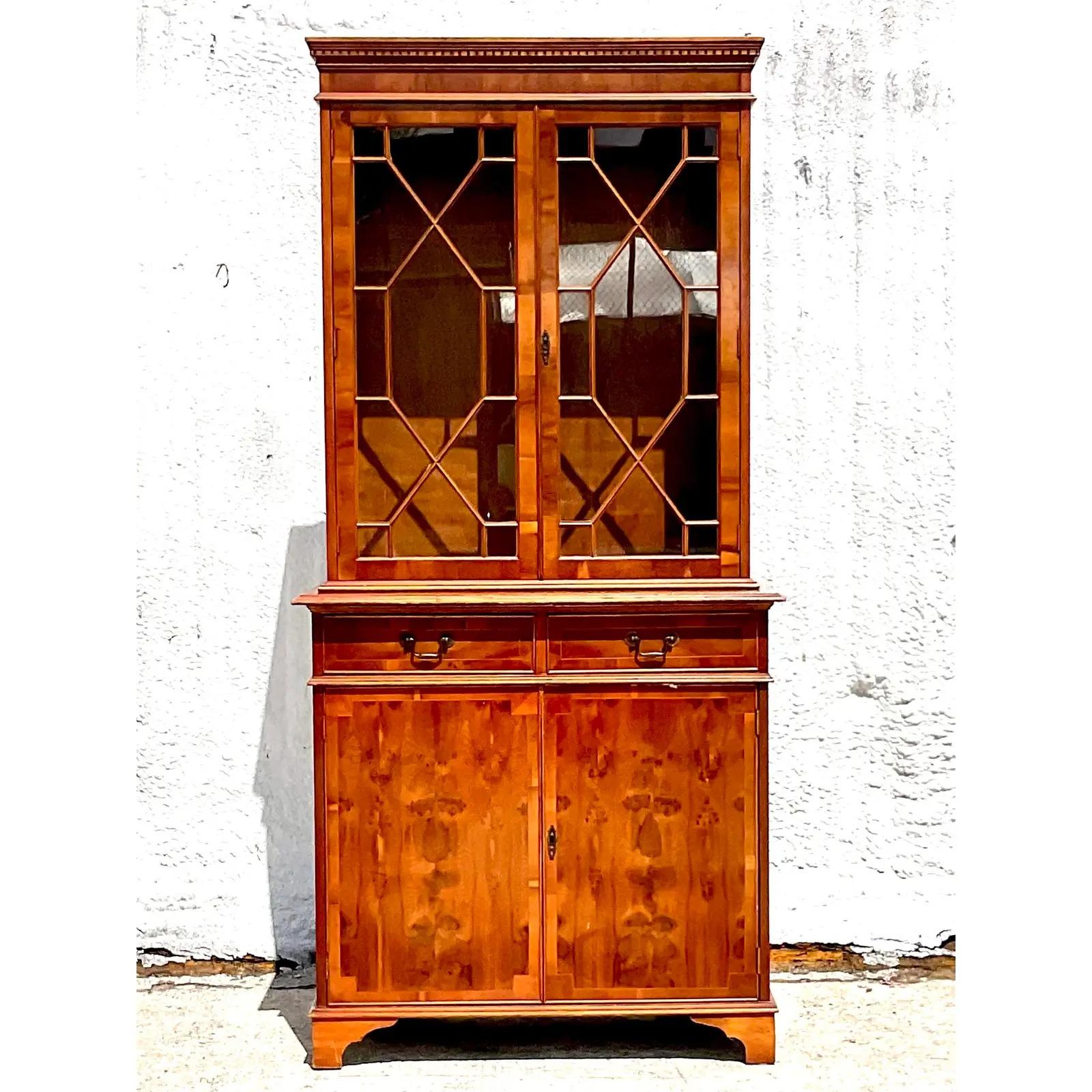 Vintage Regency flame mahogany display cabinet. Incredible wood grain detail with classic mullion detail on the glass doors. Lots of great storage below. Acquired from a Palm Beach estate.